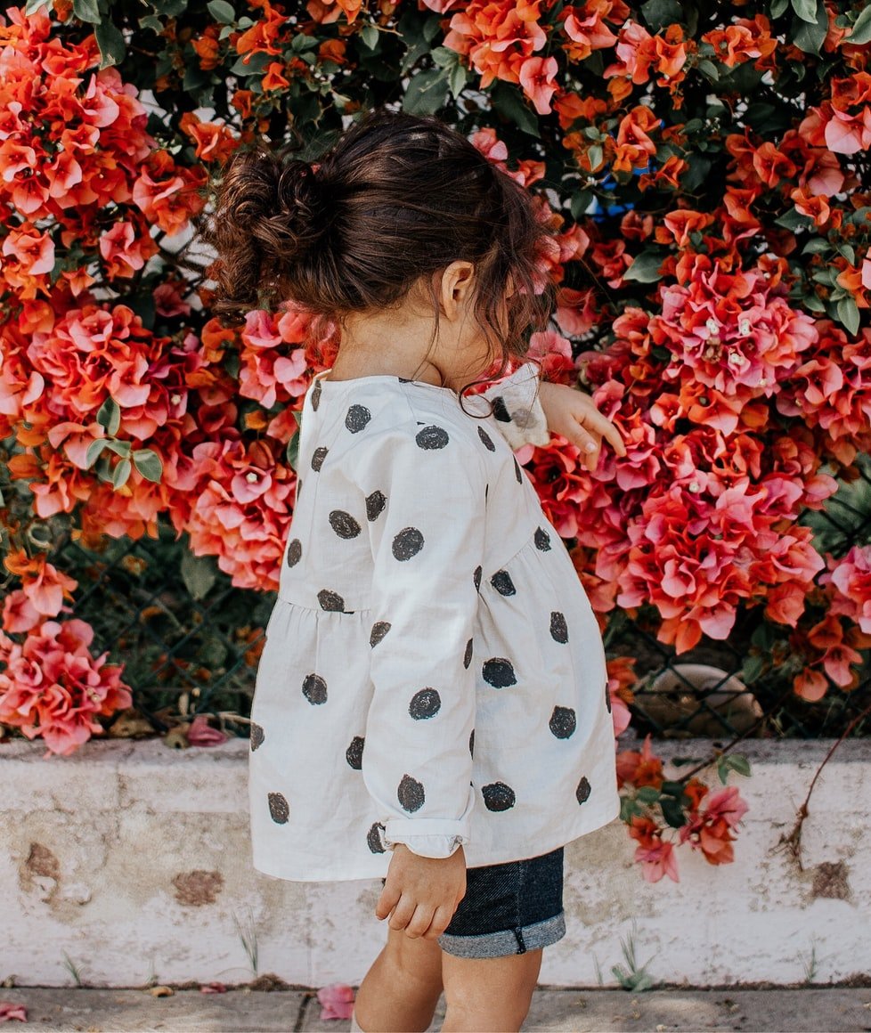 Ein kleines Mädchen, das auf einem Bürgersteig steht. | Quelle: Unsplash