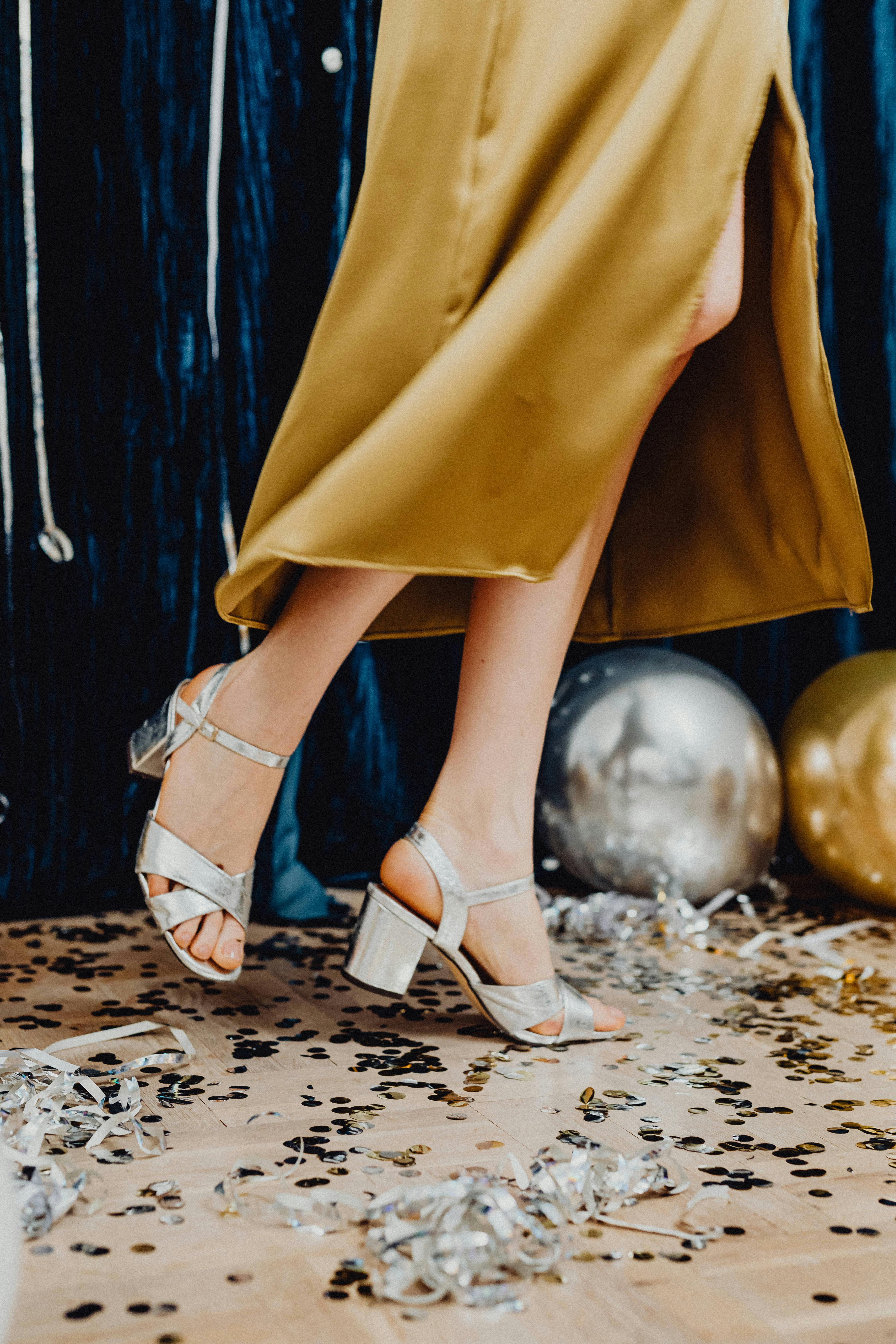 A woman wearing a gold dress and silver shoes | Source: Pexels