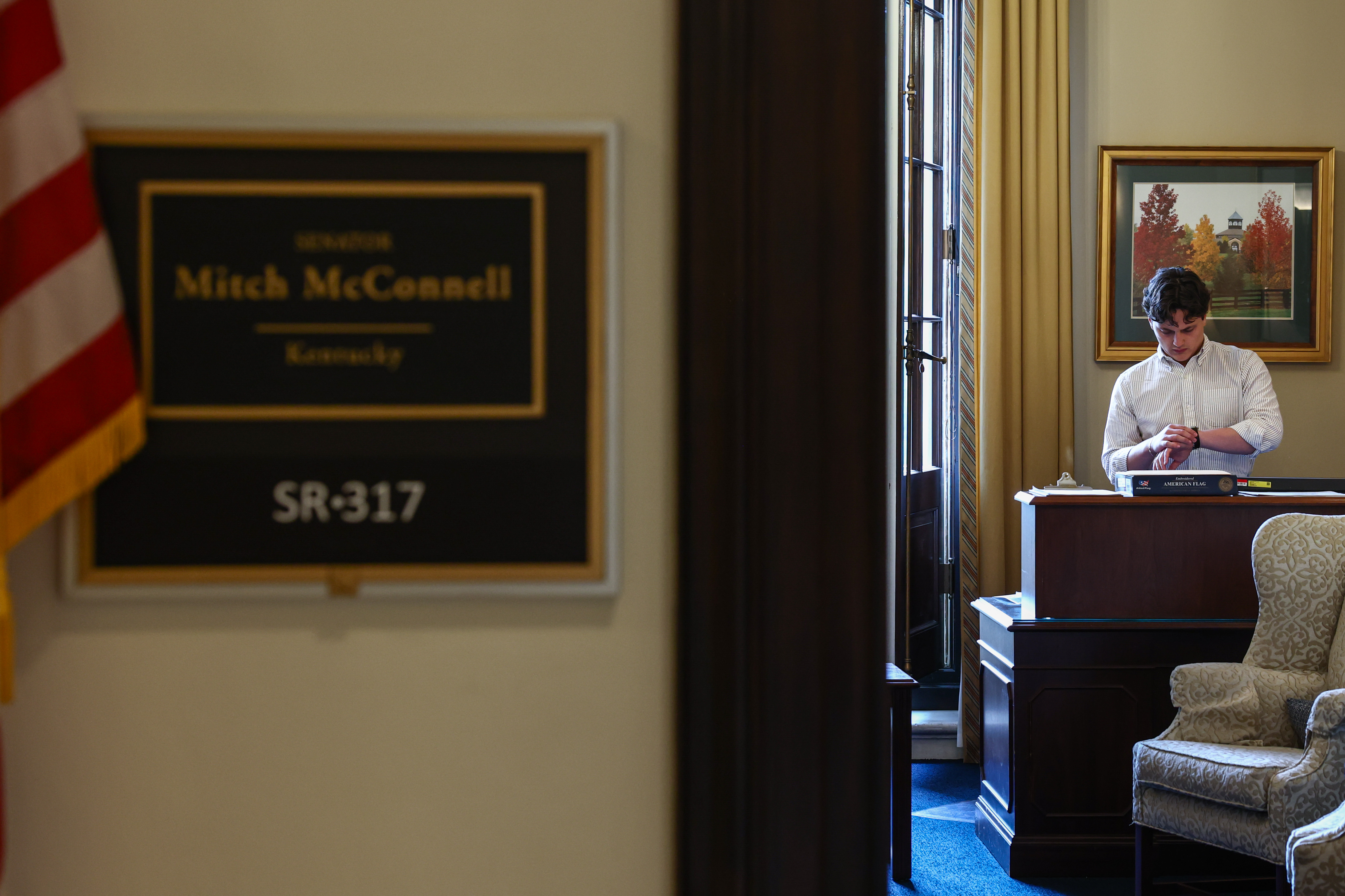 A staff member checks his watch inside Mitch McConnell's Senate office on July 8, 2026. In his later update, McConnell said he remained in close contact with his staff and continued working on Senate matters during his recovery. | Source: Getty Images