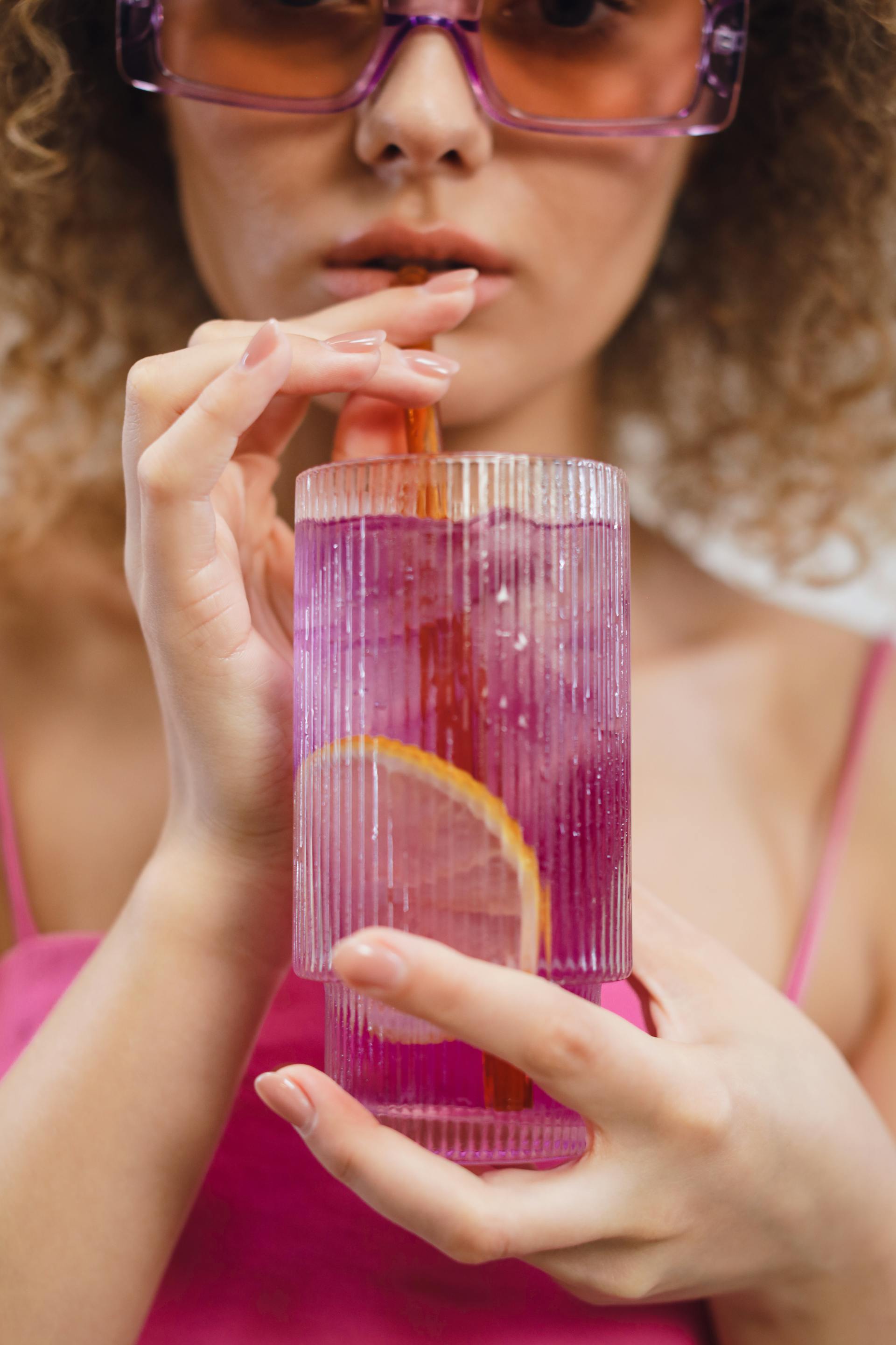 A woman drinking an iced beverage | Source: Pexels