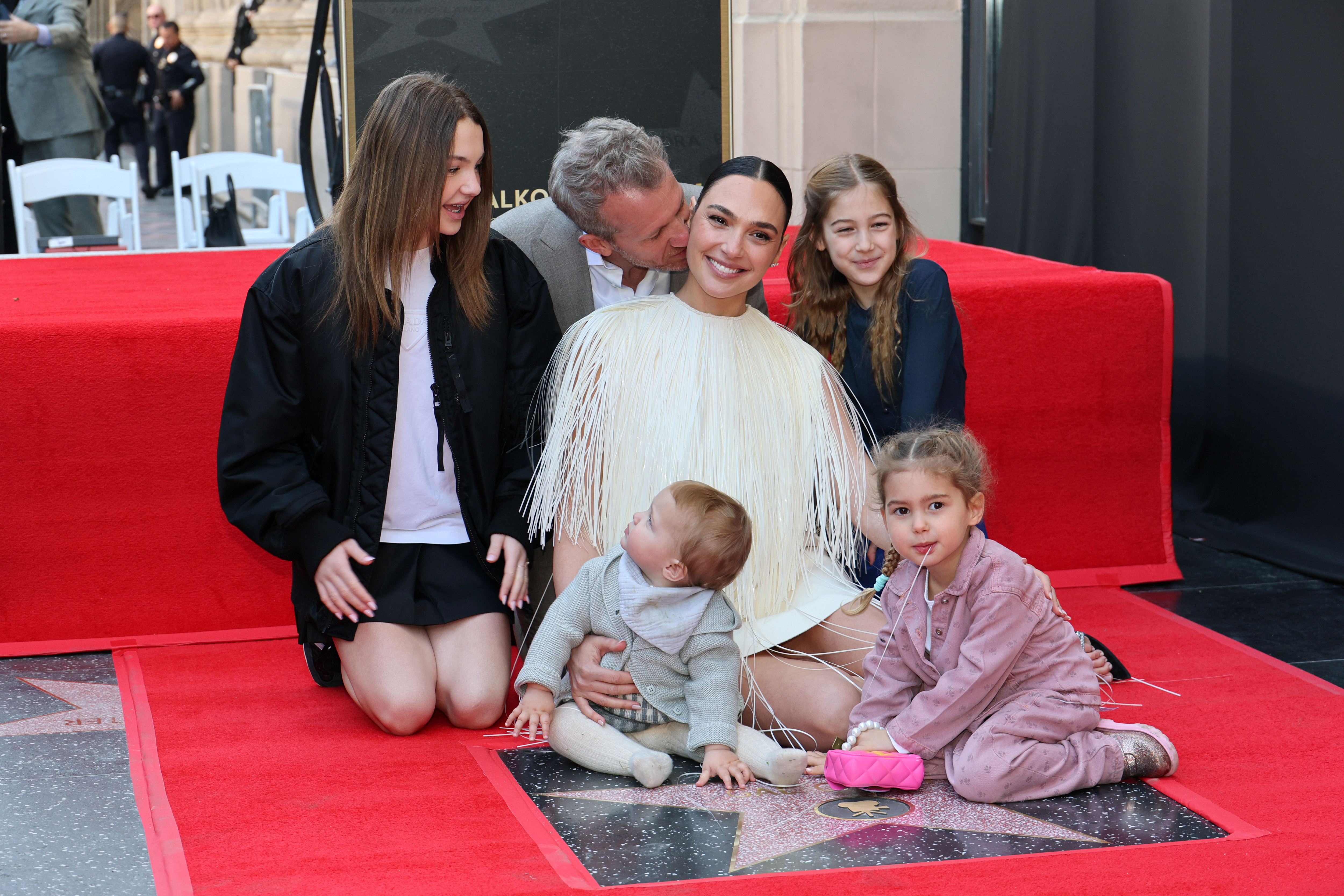 Jaron Varsano kisses his wife Gal Gadot while being pictured with their four daughters at the ceremony honoring Gal Gadot with a Star on the Hollywood Walk of Fame on March 18, 2025, in Hollywood, California | Source: Getty Images