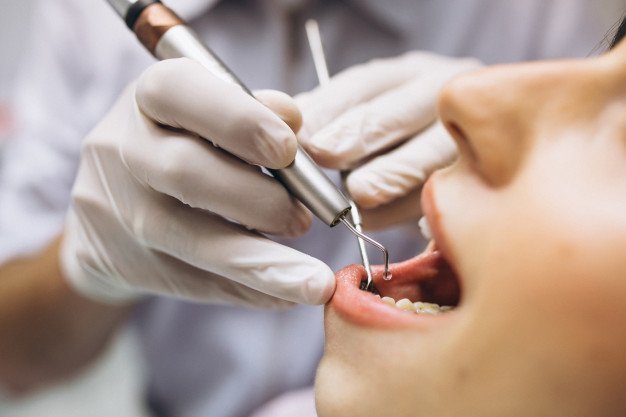 Photo of dentist examining a patient | Photo: Freepik