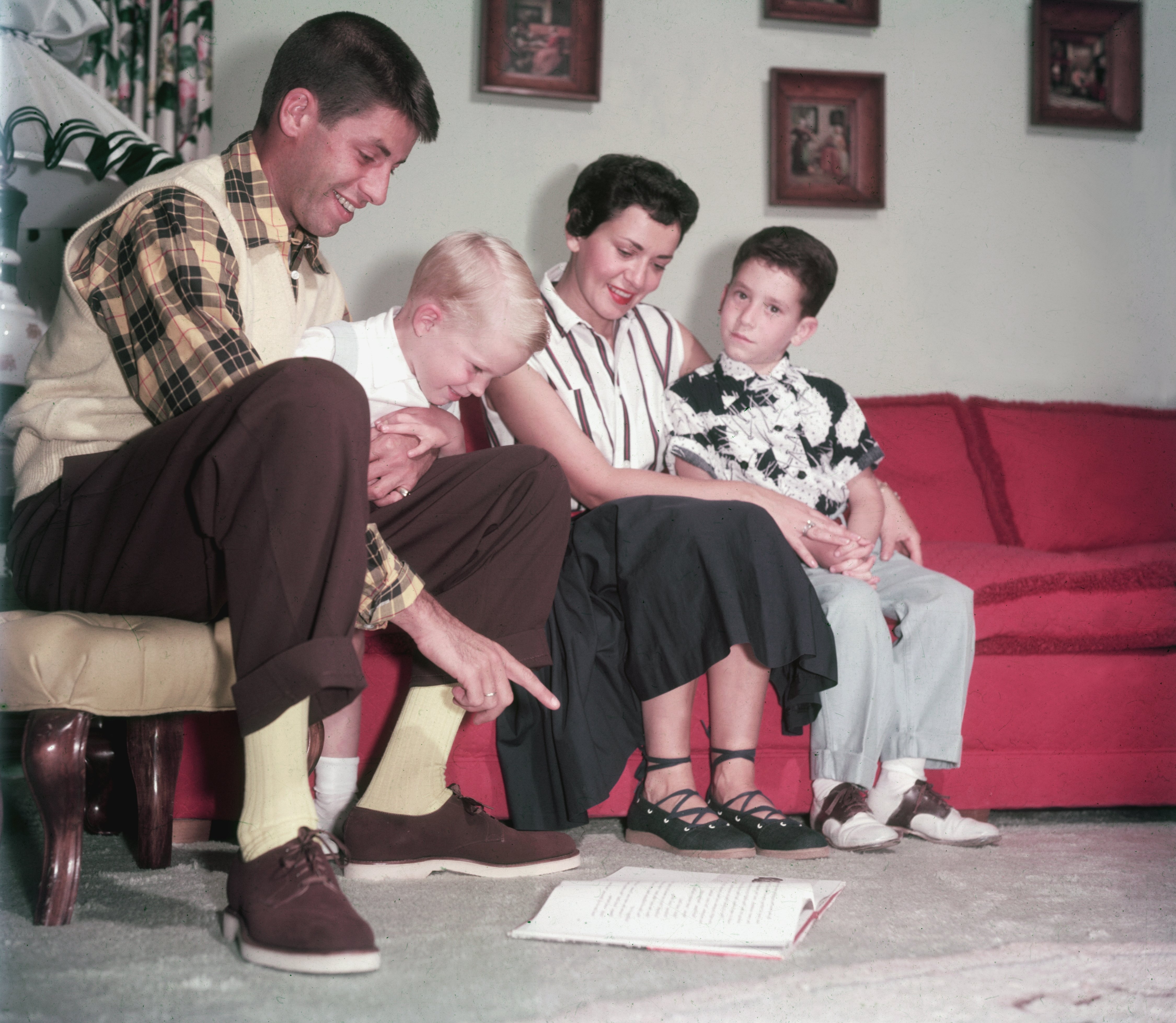 Jerry Lewis photographed sitting on a couch with wife, Patti Palmer, and their two sons, Gary and Ronald. | Source: Getty Images