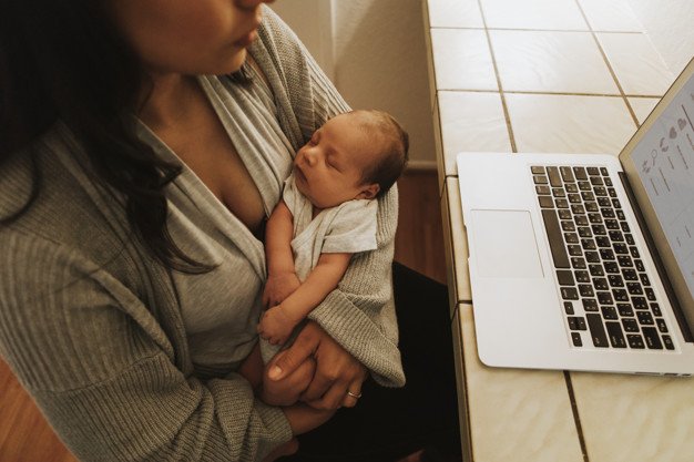 Working mom holding a baby | Source: Freepik