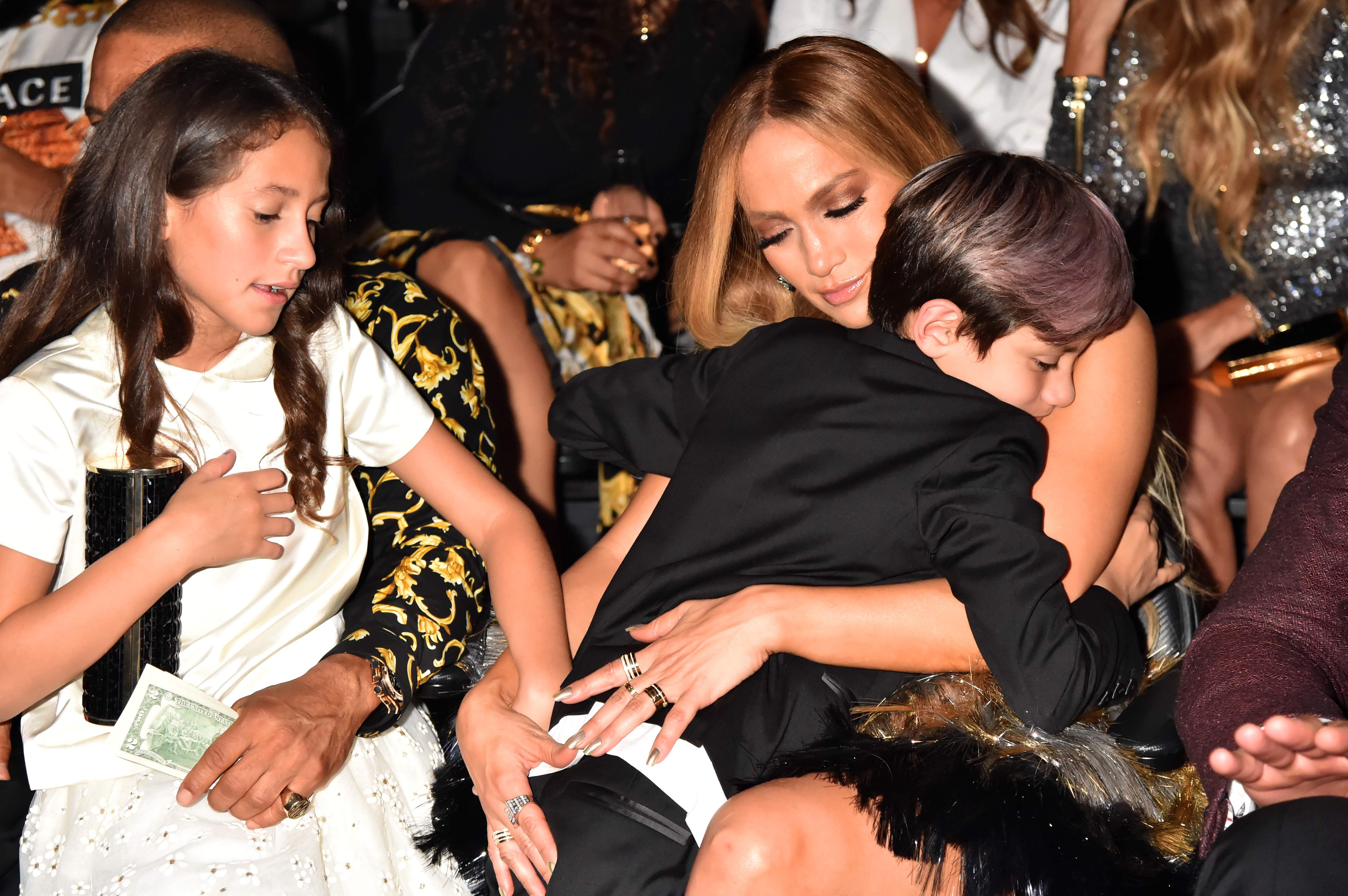 Jennifer Lopez shares a warm hug with Max while Emme is carried by an unseen celebrity at the MTV Video Music Awards at Radio City Music Hall in New York City. Even amid the glitz of a major event, Jennifer radiates her signature caring mom energy.