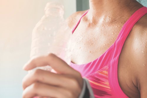 Schwitzende Frau mit einer Wasserflasche | Quelle: Shutterstock