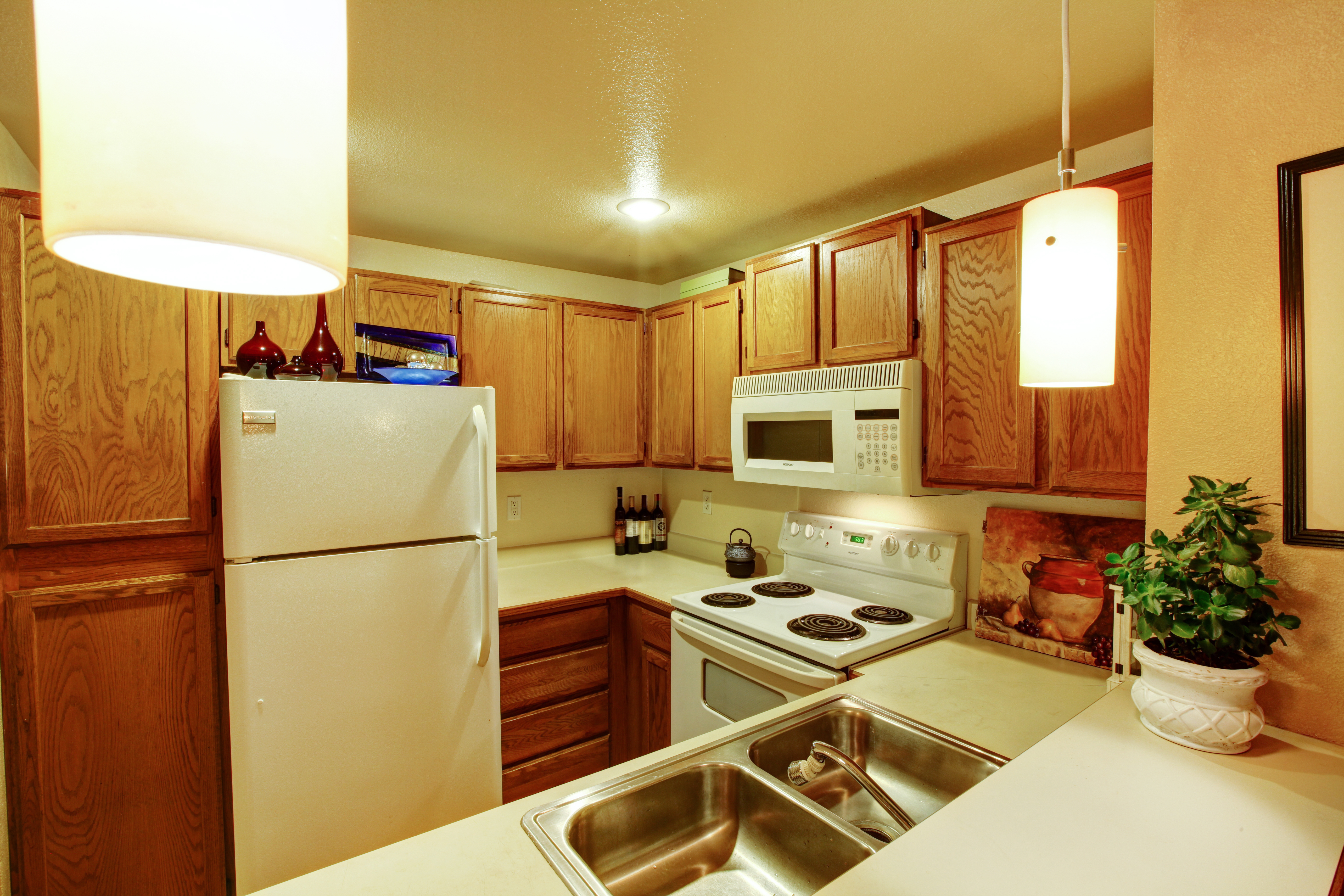 A view of kitchen cabinets with sink and white old appliances | Source: Shutterstock