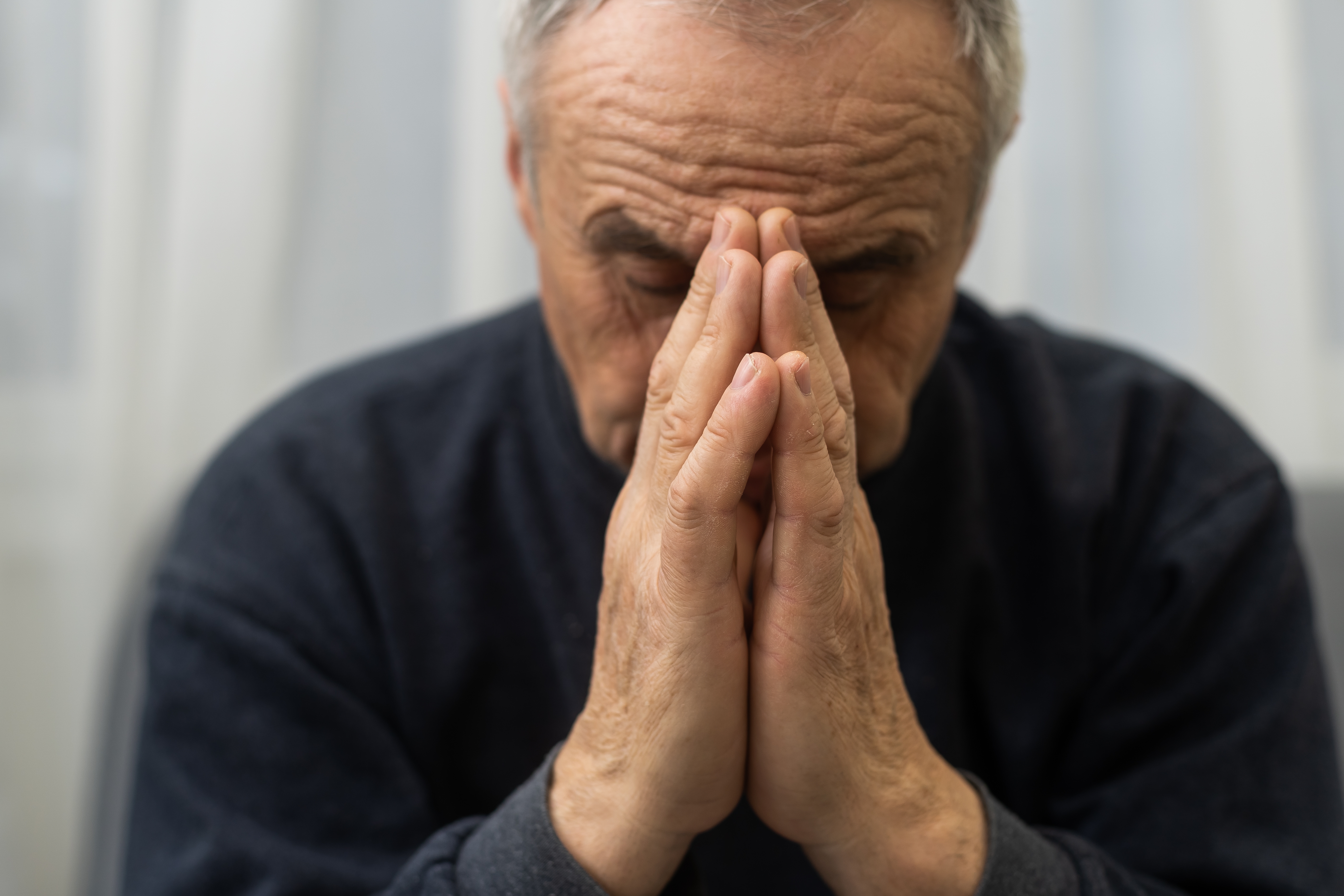 A stressed aged man sitting on a sofa | Source: Shutterstock