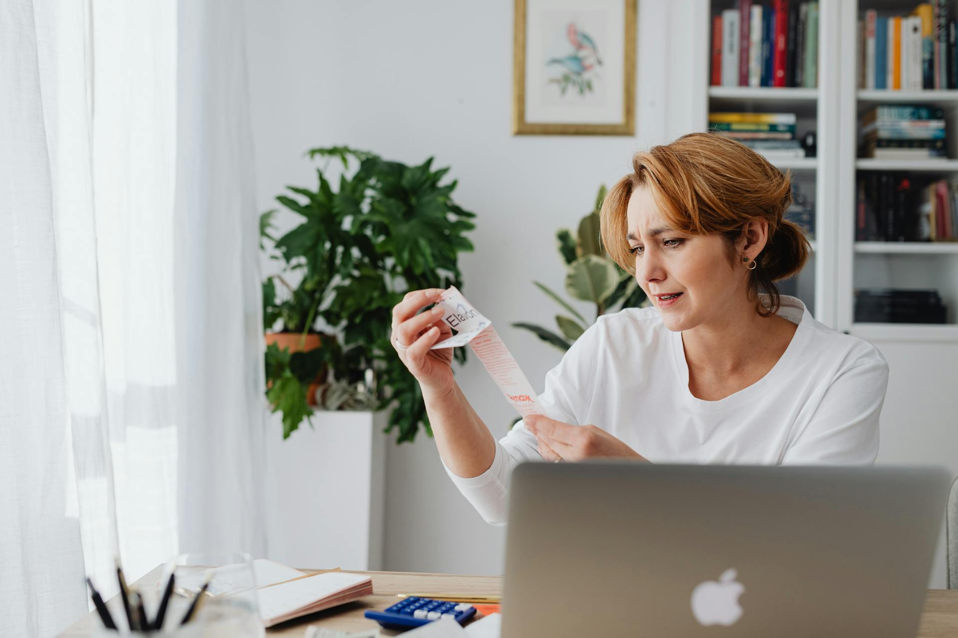A woman sitting behind a desk looking at a receipt | Source: Pexels