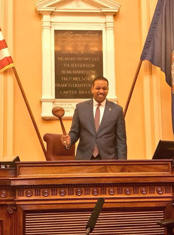Justin Fairfax poses with a gavel inside a government chamber in Fairfax County, Virginia | Source: Facebook/justin.fairfax.2025