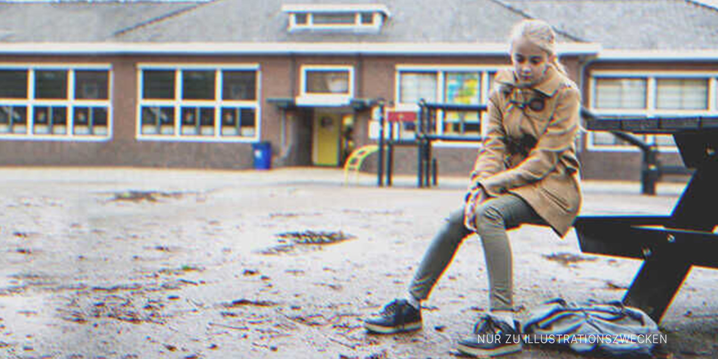 Ein Mädchen sitzt vor einem Schulgebäude. | Quelle: Getty Images