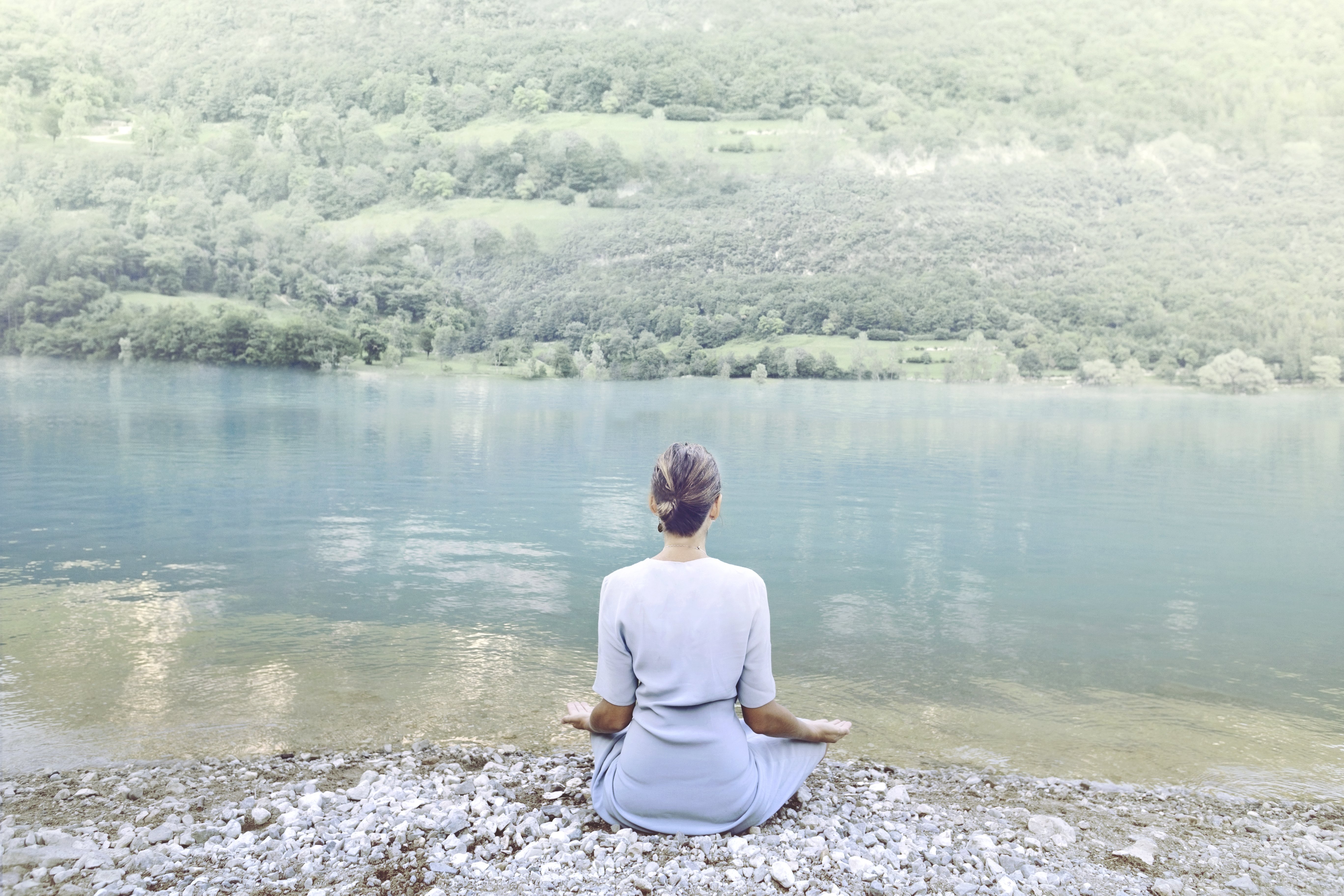 Mujer meditando delante de un lago. | Foto: Shutterstock