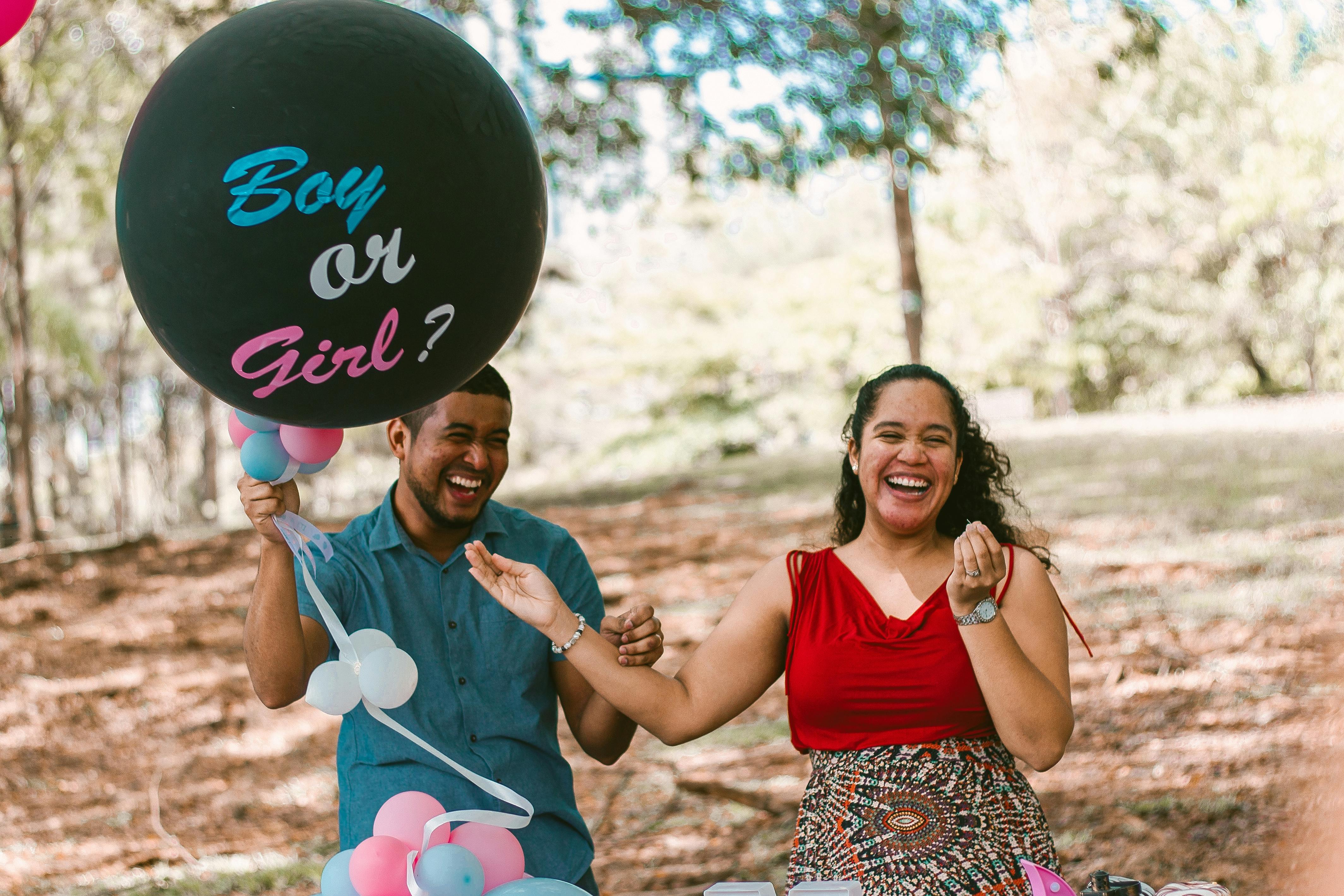 A man and pregnant woman laughing at a gender reveal party | Source: Pexels