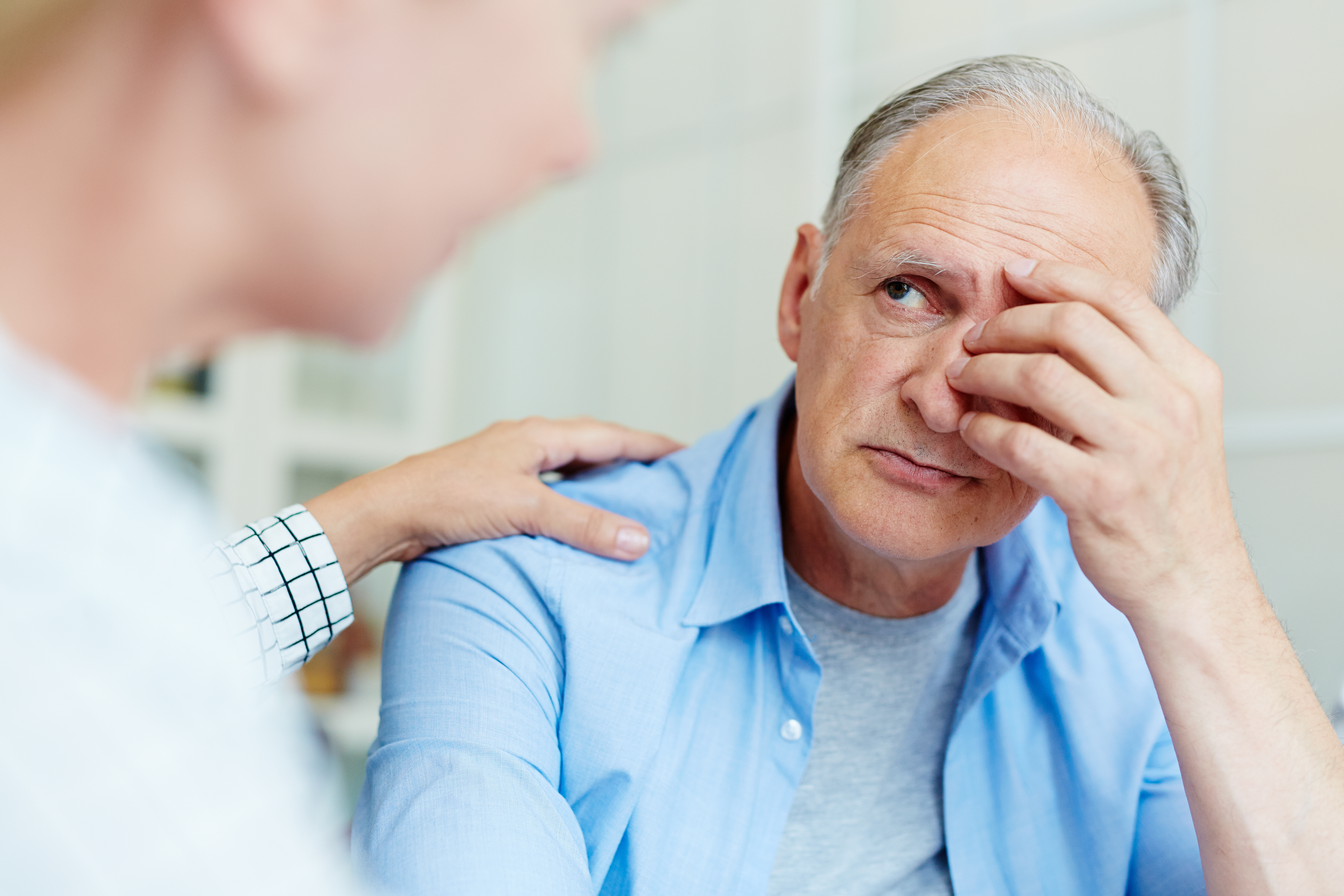 A man listening to a woman who's touching his shoulder | Source: Shutterstock