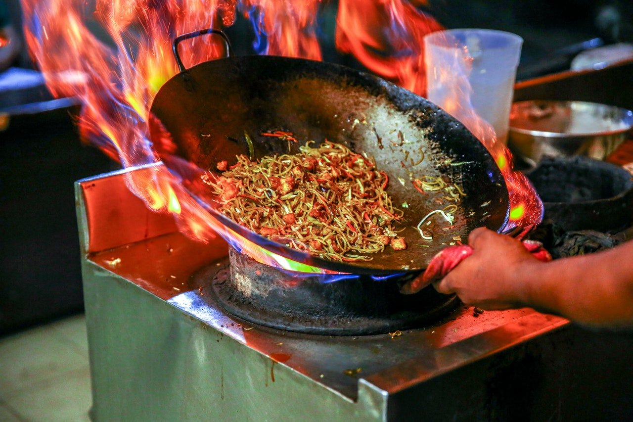 Person making noodles in a wok | Source: Pexels