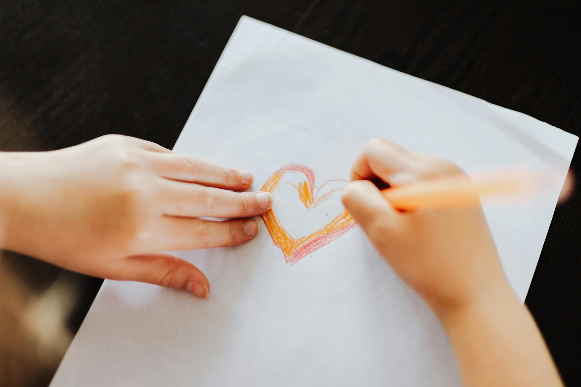 A child drawing a heart on a piece of paper | Source: Pexels
