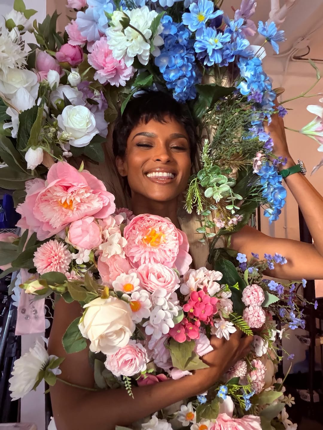 The singer smiles while surrounded by colorful floral arrangements | Source: Instagram/ciara