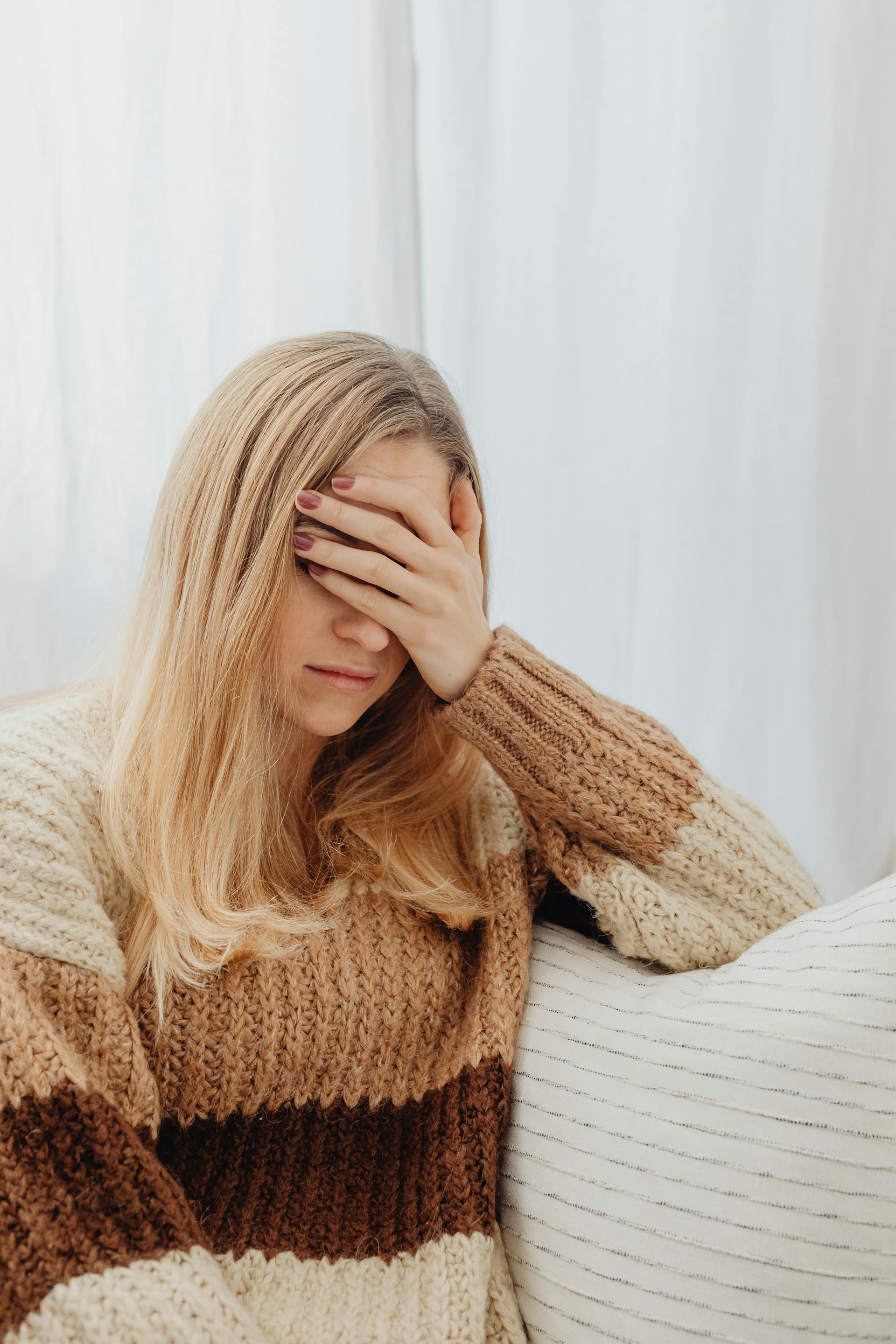 A distressed woman with a hand on her forehead | Source: Pexels