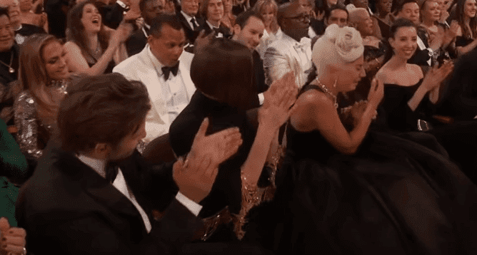 Lady Gaga reacting to winning her first Academy Award while sitting next to Irina Shayk | Photo: ABC