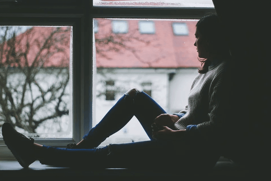 A sad woman siting b her window side and thinking deeply. | Photo: Pixabay