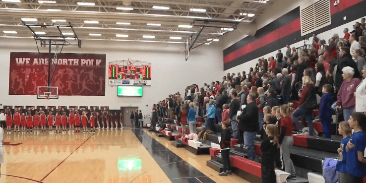 Audience standing and singing the National Anthem ant North Polk | Photo: WHO TV Channel 13 News