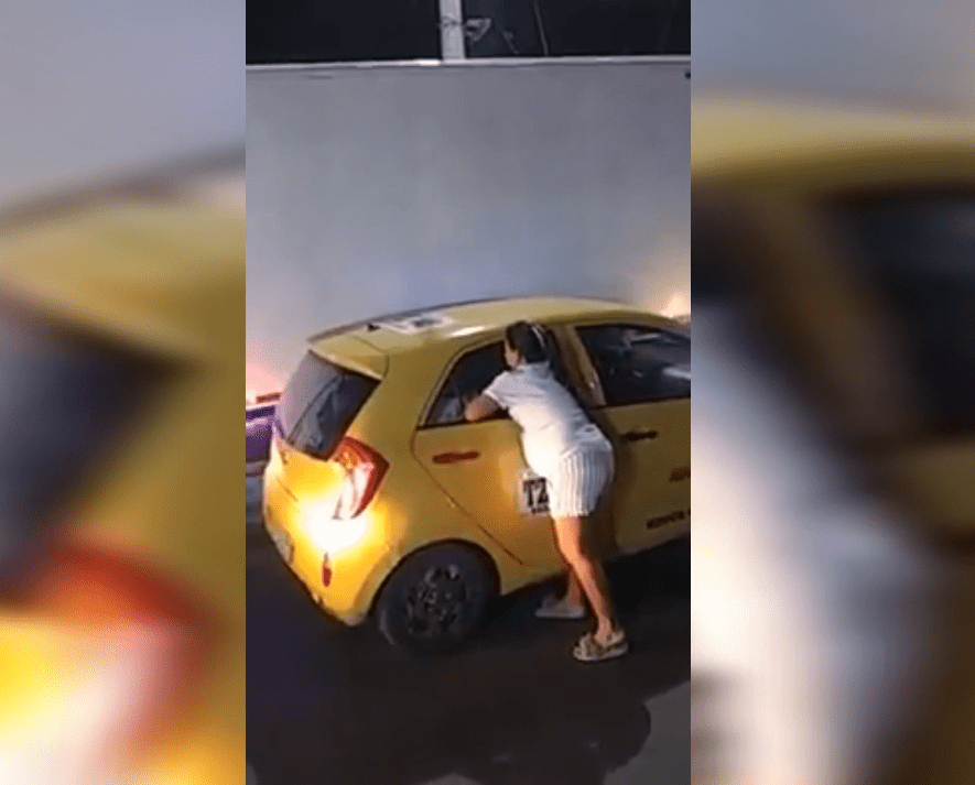 La mujer embarazada intenta quitar el seguro de la puerta, hasta que logra abrirla. Fuente: YouTube / El Mundo Viral