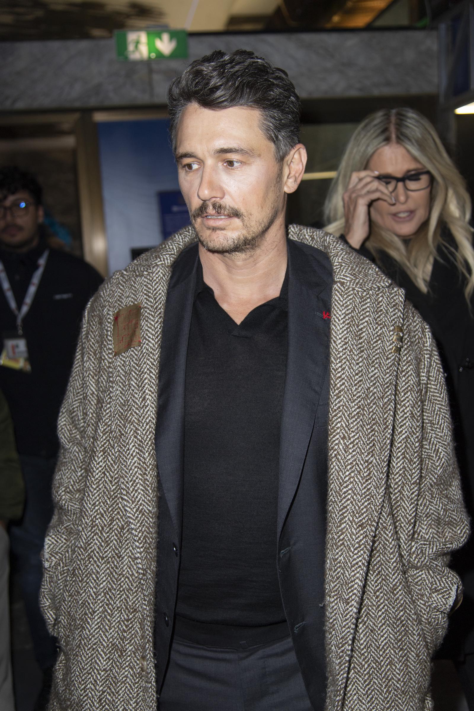 Wearing a heavy coat and trimmed hair, Franco attends the Torino Film Festival. His serious expression and updated look drew renewed attention after time away from the spotlight.