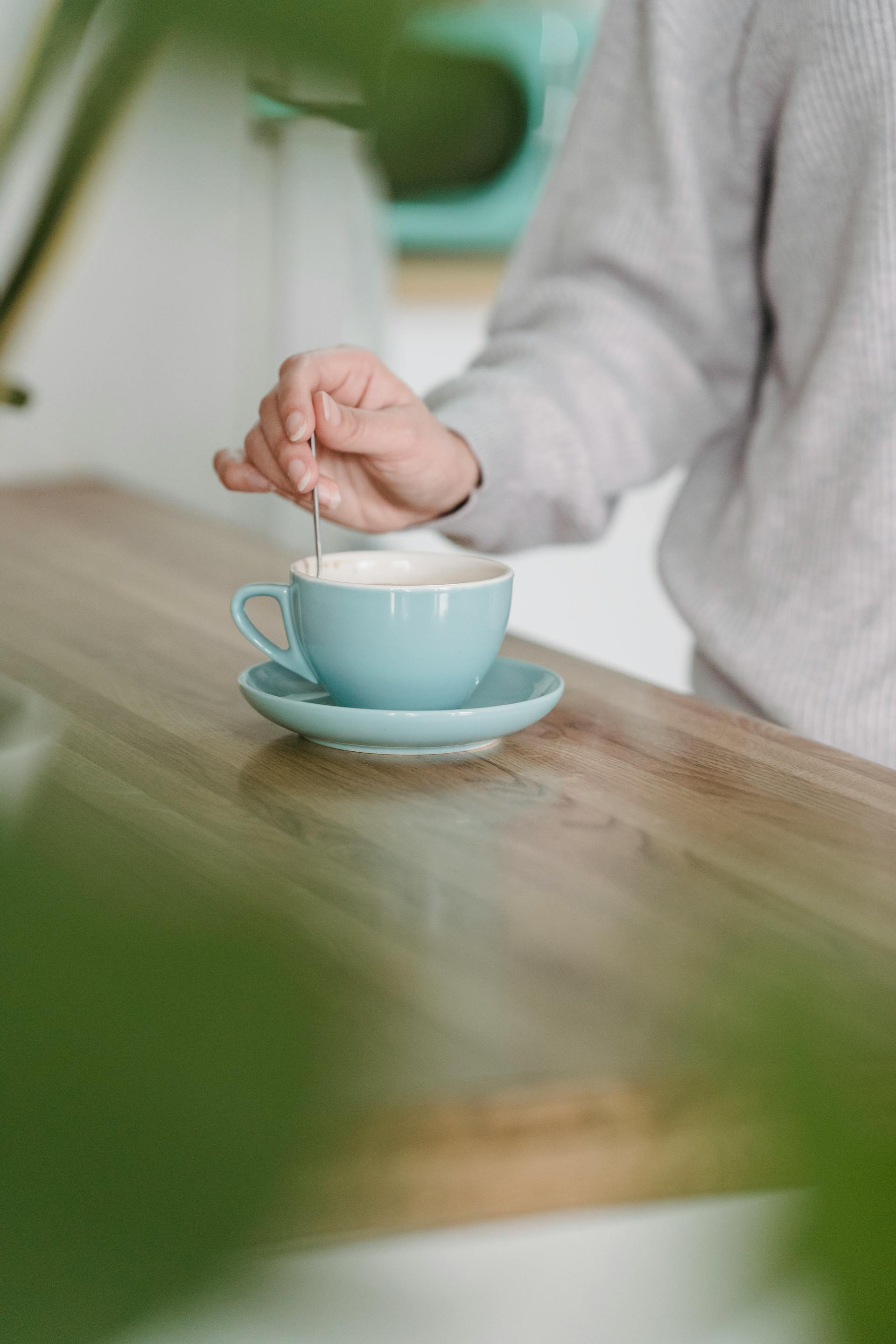 A closeup of a woman stirring her cup of coffee in the kitchen | Source: Pexels