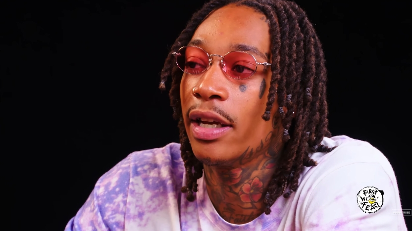 Wiz Khalifa discusses his longtime tattoo artist and Taylor Gang collaborator, Tuki Carter, during an episode of "Hot Ones" in a video shared on July 26, 2018. | Source: YouTube/First We Feast