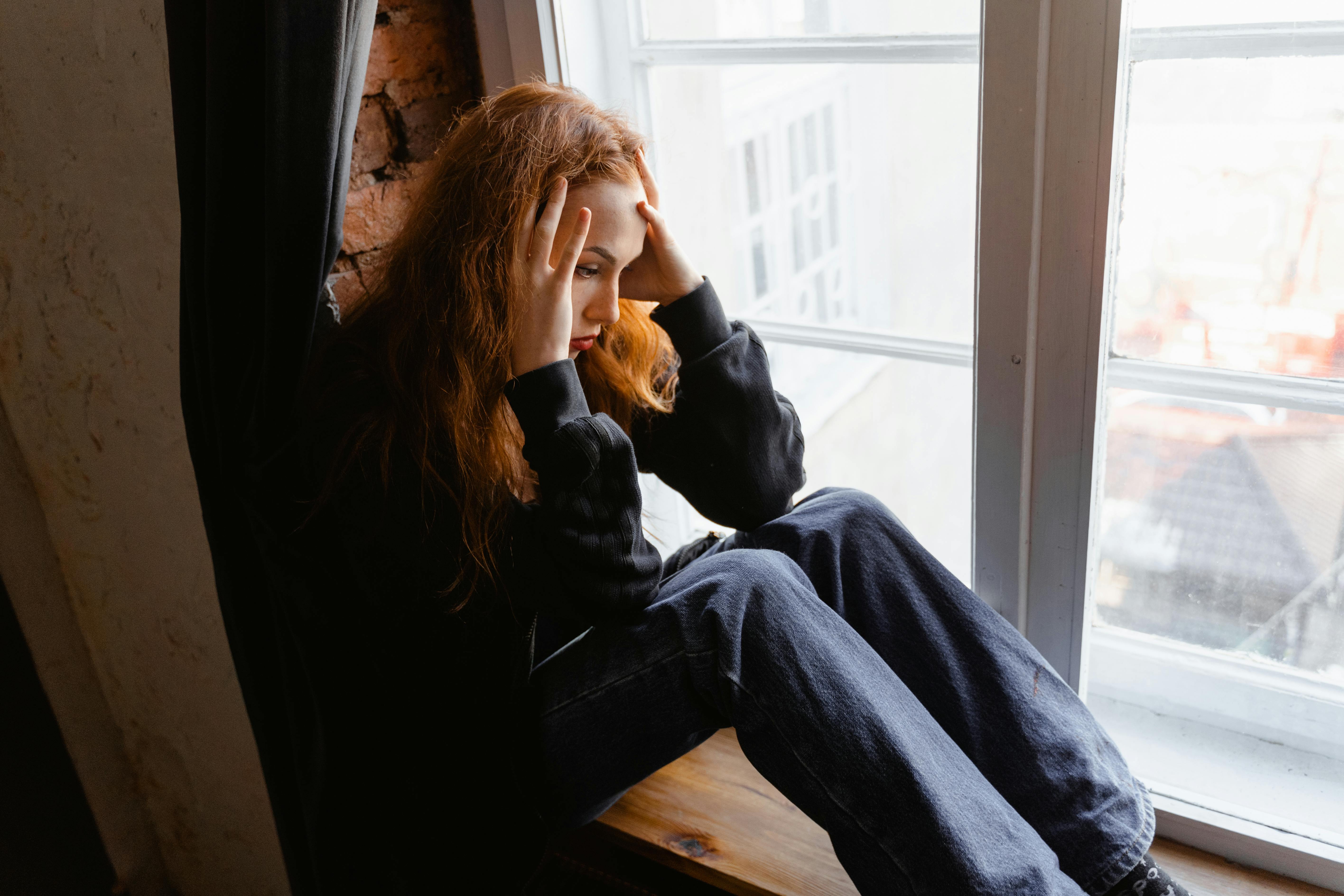 An upset woman with her head in her hands | Source: Pexels