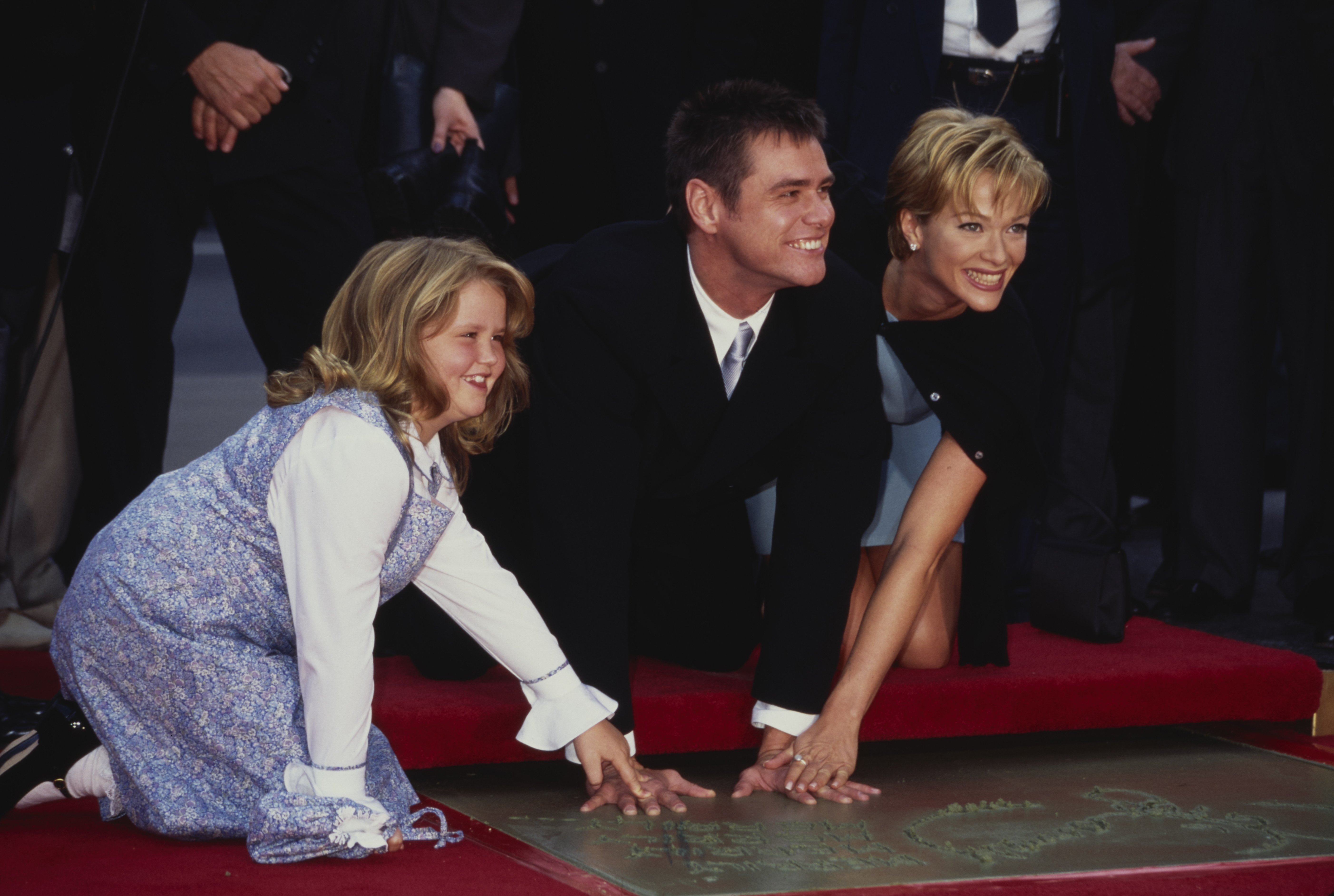 Jane Carrey with her father Jim Carrey and Lauren Holly during Jim Carrey's Footprint Ceremony at Mann's Chinese Theatre on November 2, 1995 in Hollywood, California | Source: Getty Images