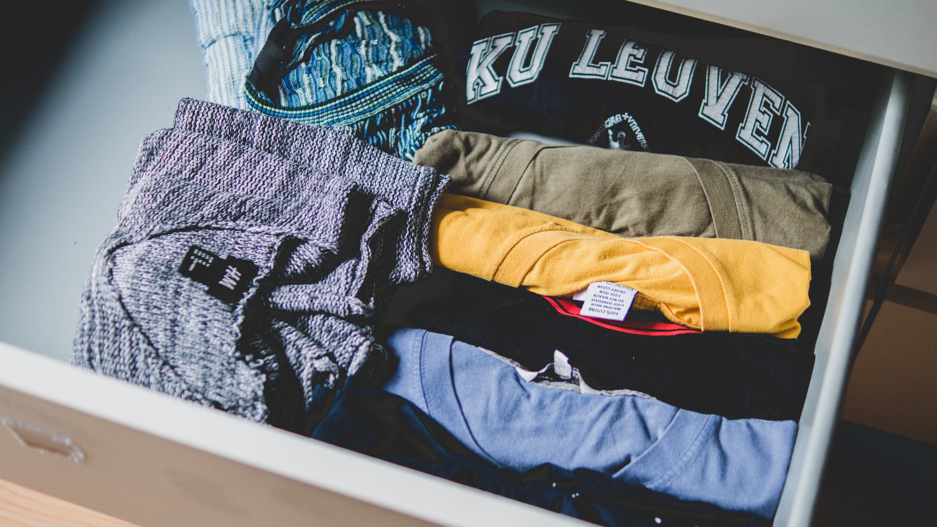 Folded colored shirts placed in a drawer | Source: Pexels