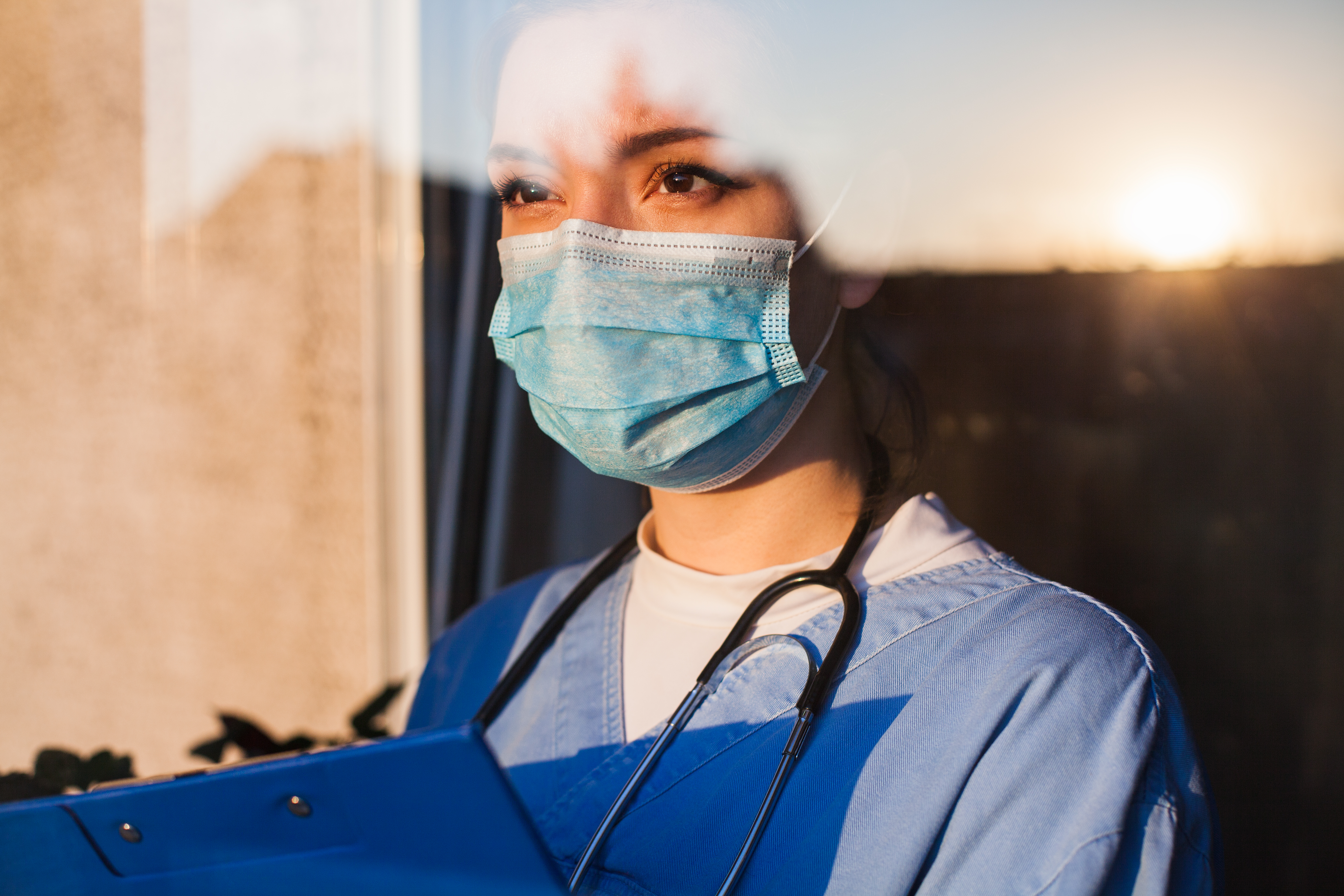 A nurse staring outside as she contemplates her life | Source: Shutterstock