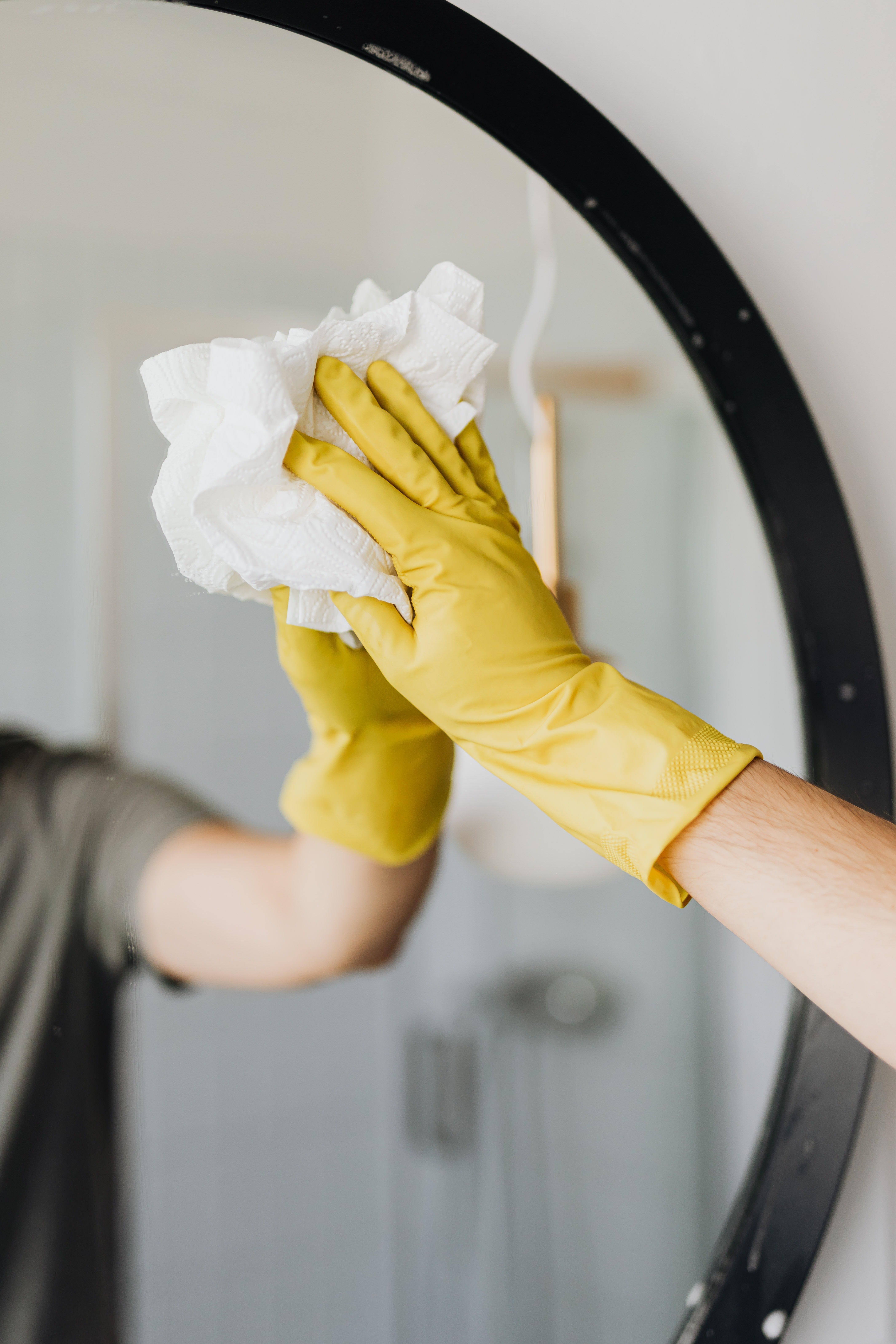 Persona limpiando un espejo. | Foto: Pexels