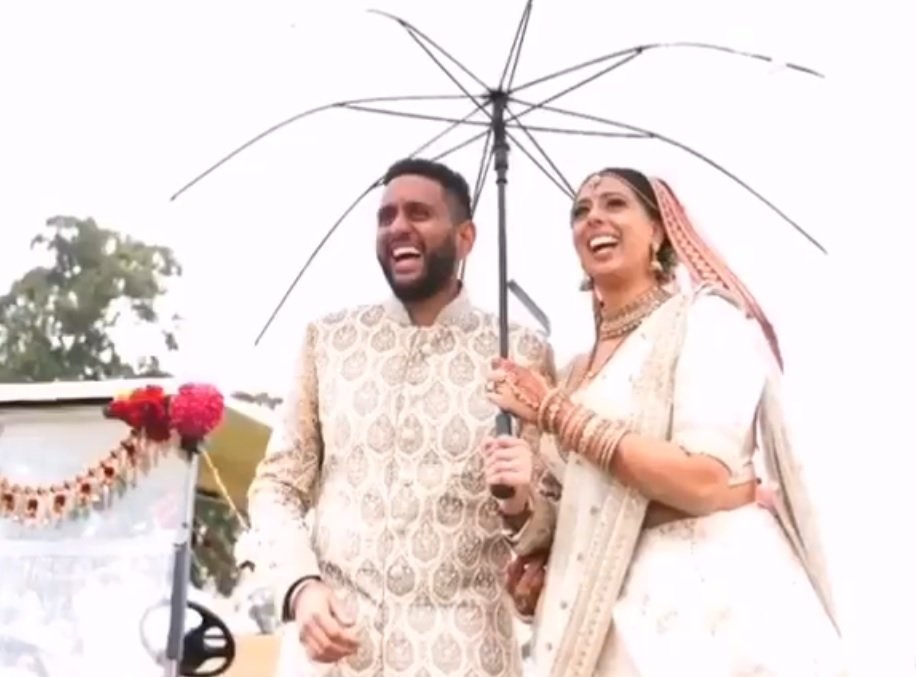 Ehepaar steht unter Regenschirm | Quelle: Facebook/Abisheik Khanna