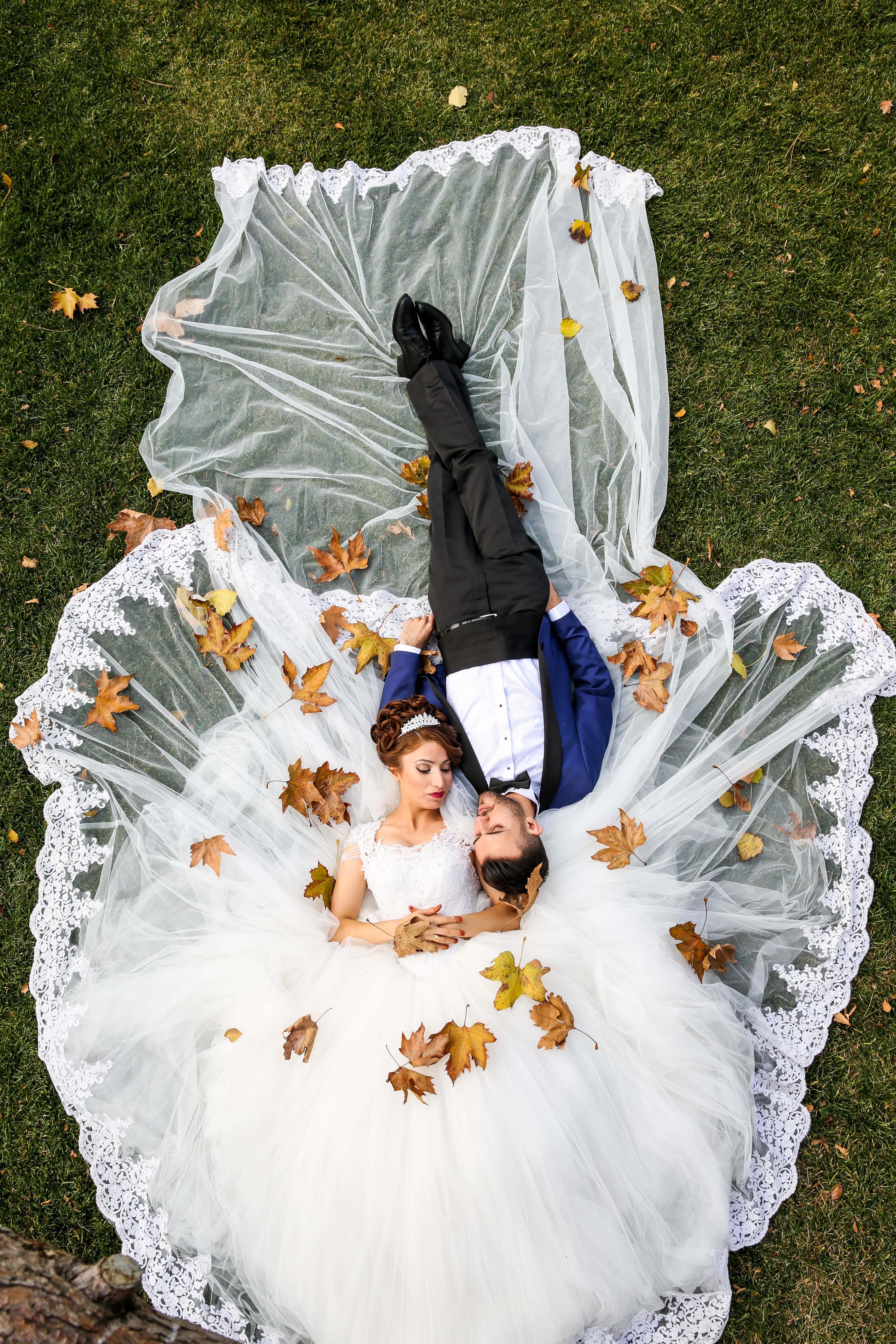 A newlywed couple laying on the grass in the wedding clothes | Source: Pexels