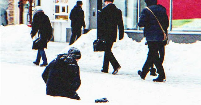 A person sitting in the snow on the street | Source: Shutterstock