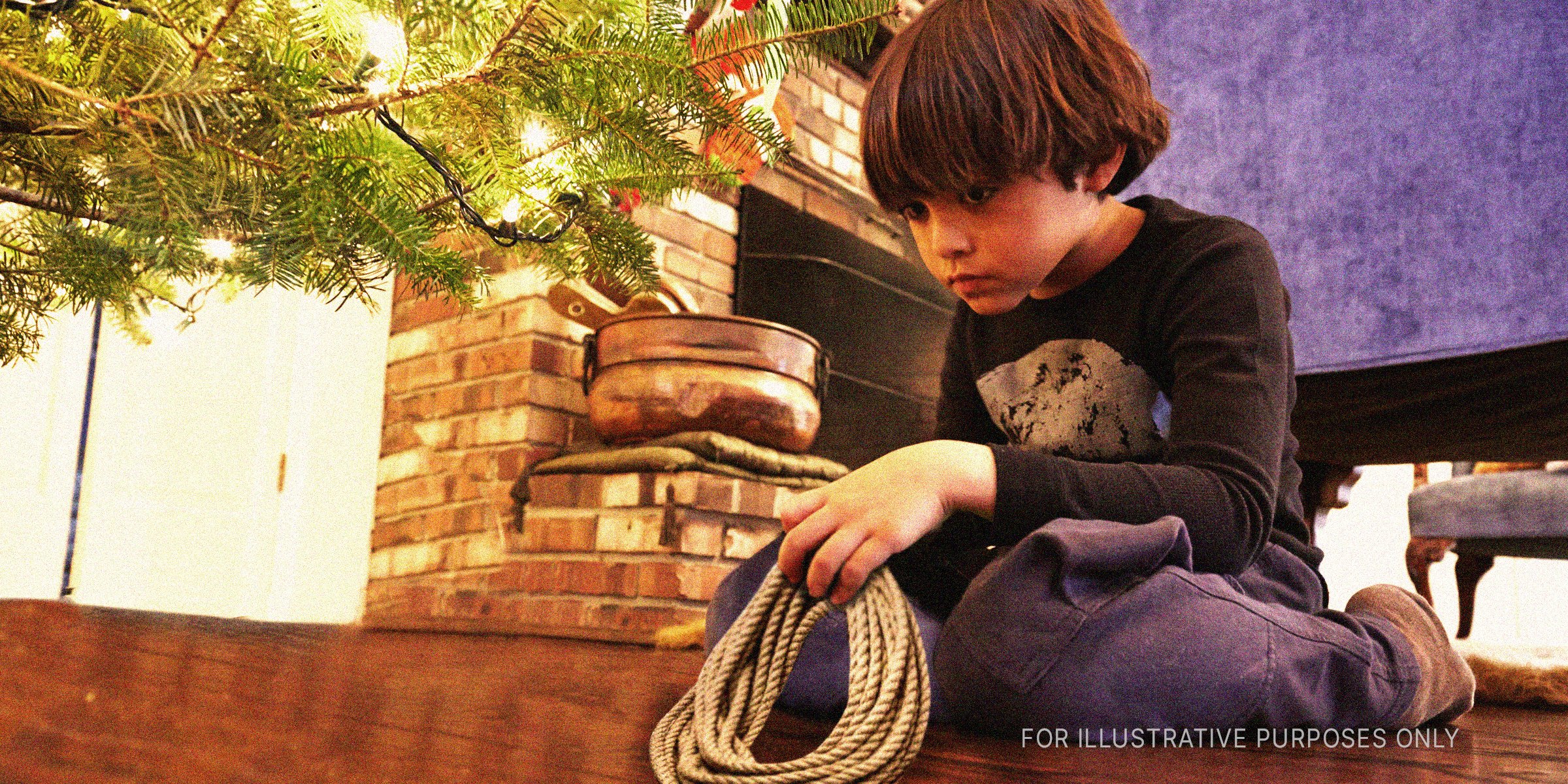 Boy with a rope under a Christmas tree | Source: Getty Images 