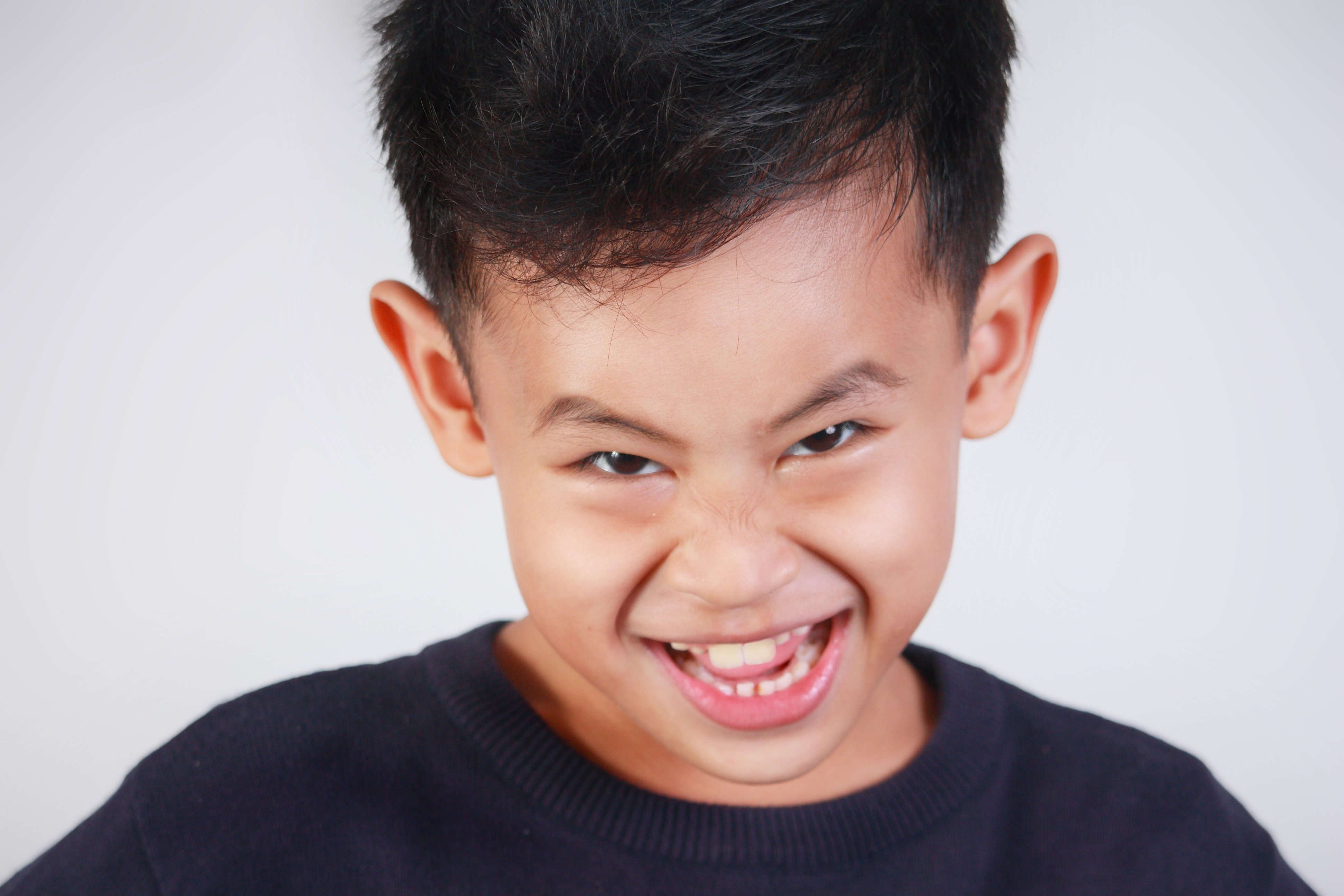 Dark haired boy with naughty facial expression. | Photo: Shutterstock