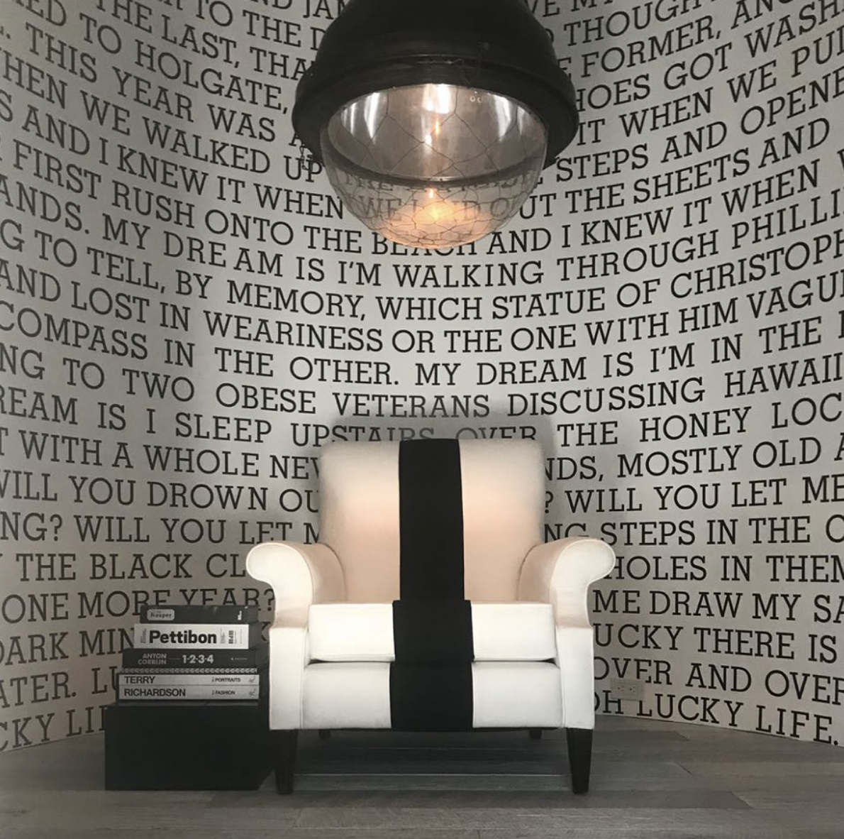 Striped armchair beneath industrial lighting in front of a floor-to-ceiling text mural inside Diane Keaton’s Sullivan Canyon home, dated December 4, 2017 | Source: Instagram/diane_keaton