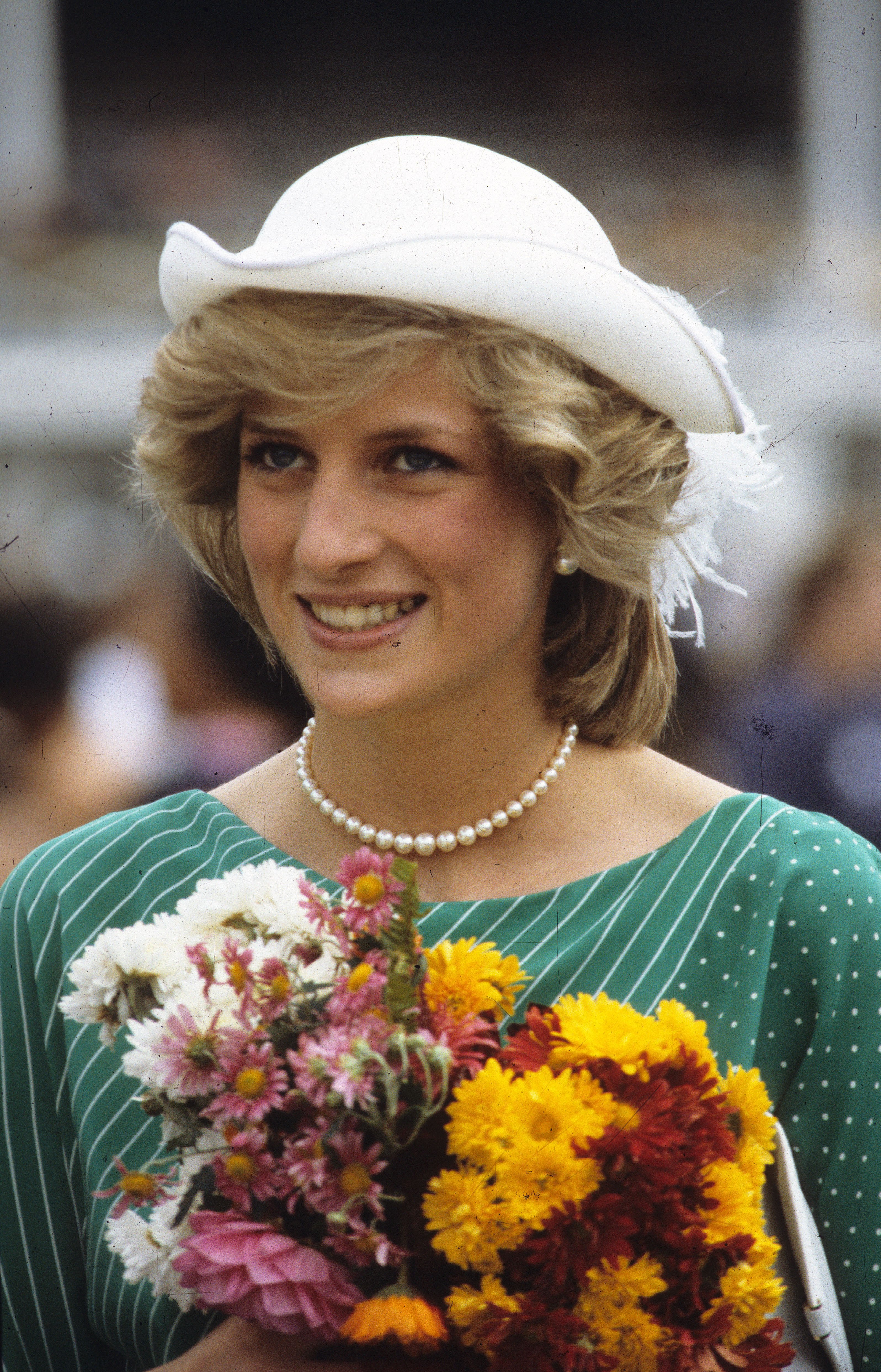 Princess Diana wearing a green and white striped dress and white hat at a welcome ceremony at the Eden Park Stadium in 1983 in Auckland, New Zealand | Photo: Anwar Hussein/Getty Images
