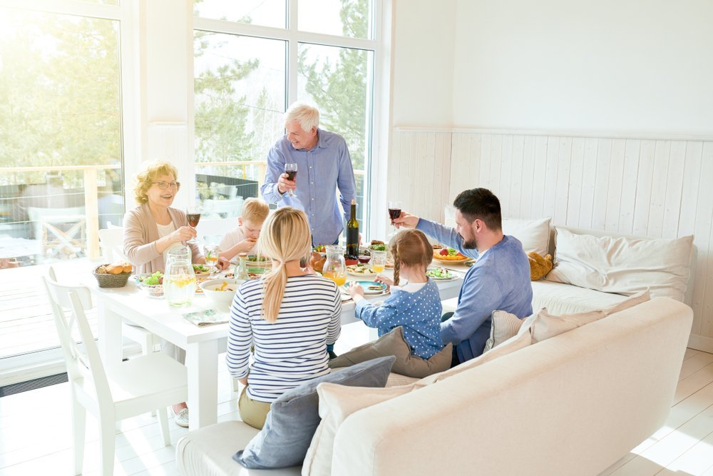 Portrait of happy two generation family enjoying dinner together sitting at festive table | Photo: Shutterstock