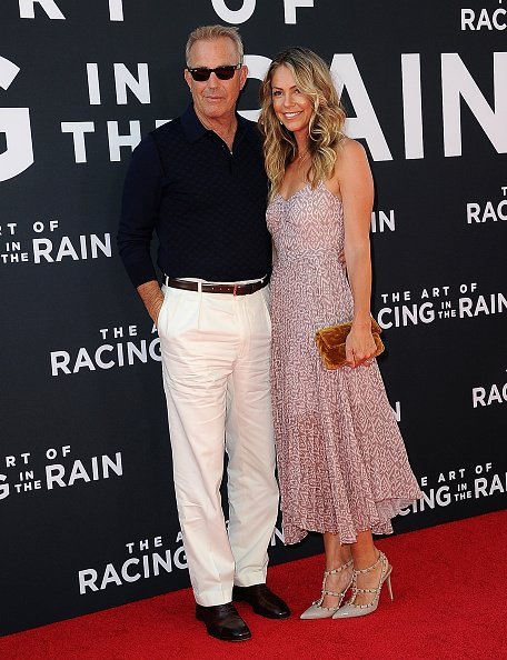 Kevin Costner and Christine Baumgartner arrive for the Premiere Of 20th Century Fox's "The Art Of Racing In The Rain" held at El Capitan Theatre | Photo: Getty Images