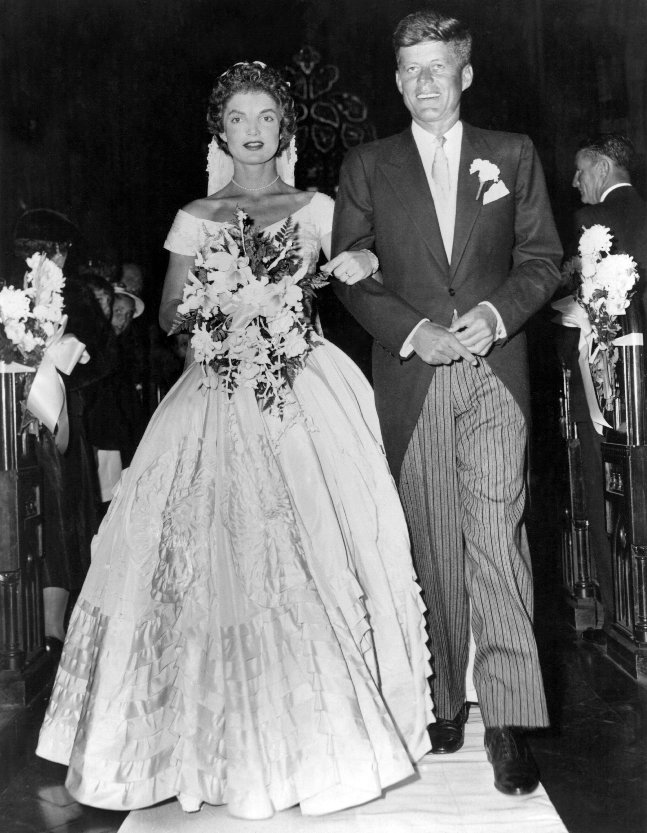Senator John Fitzgerald Kennedy escorts his bride Jacqueline Lee Bouvier shortly after their wedding ceremony on September 12, 1953, at Newport, Rhode Island | Source: Getty Images