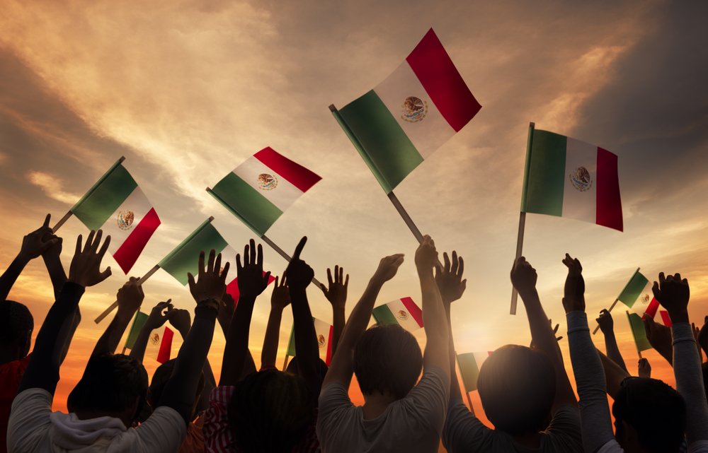 Grupo de personas con banderas mexicanas.| Fuente: Shutterstock Grupo de personas con banderas mexicanas.| Fuente: Shutterstock