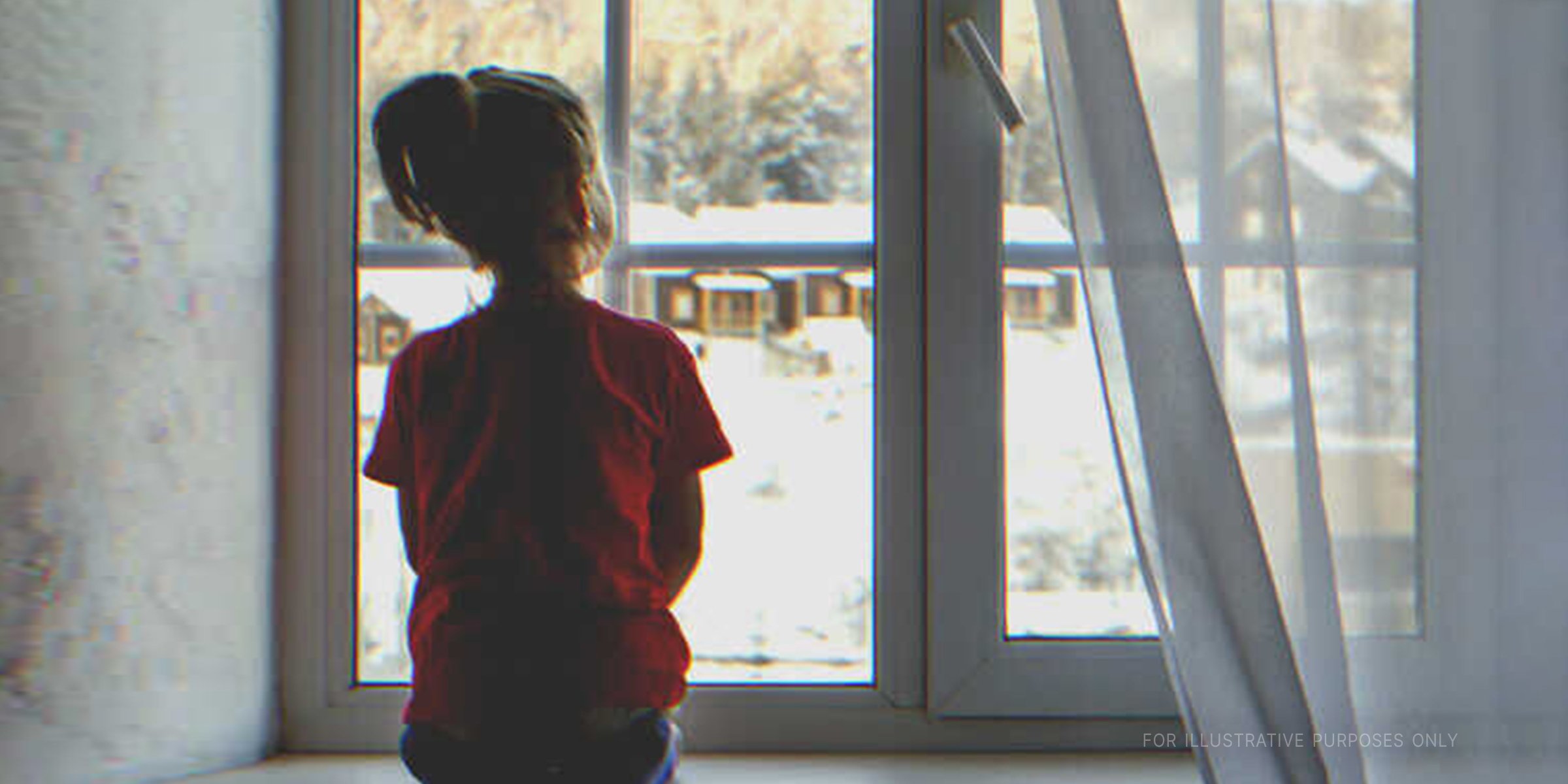 A girl staring out a window. | Source: Shutterstock