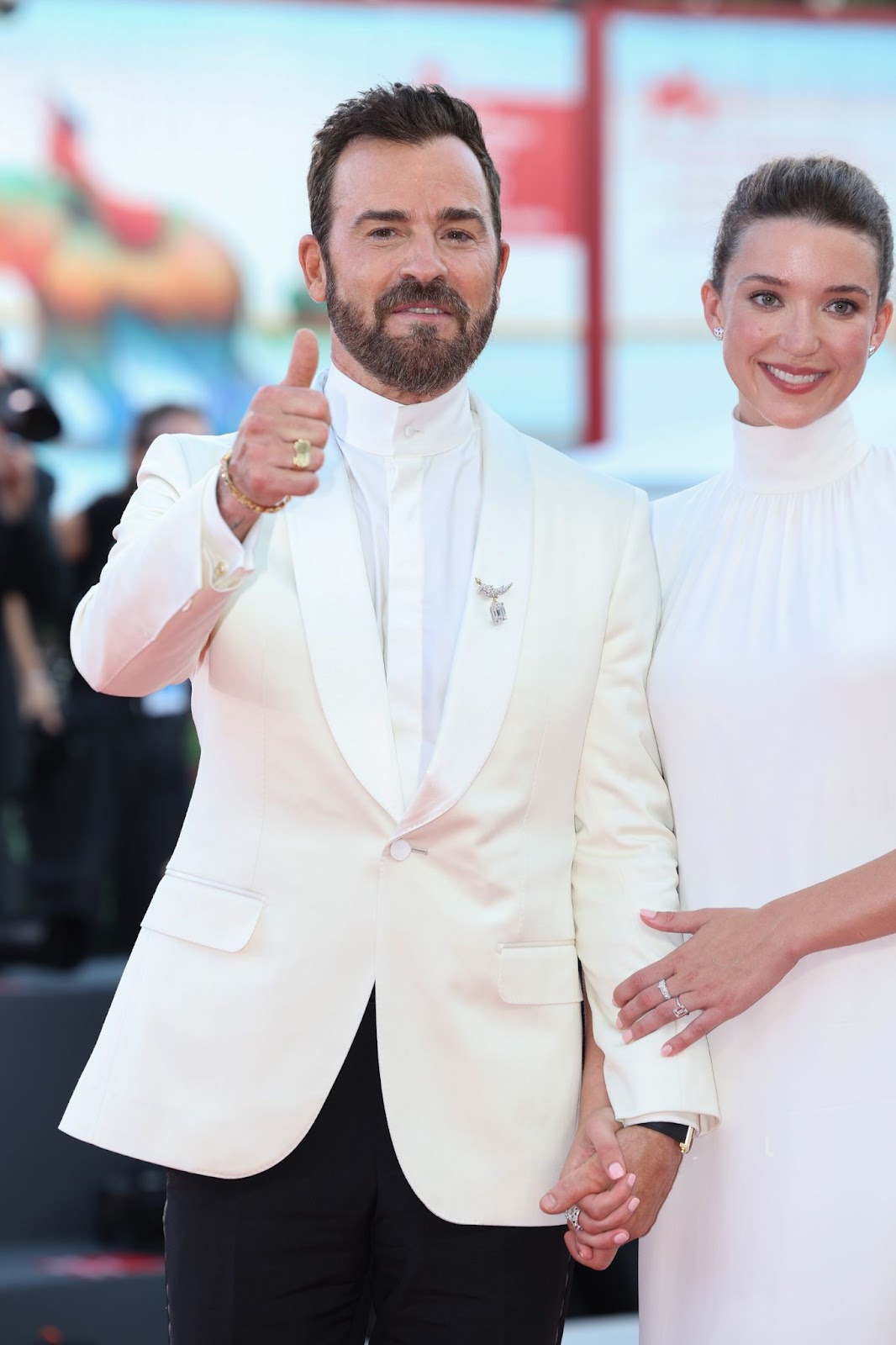 Justin Theroux giving a thumbs up while posing with Nicole Brydon Bloom whose engagement ring is slightly visible | Source: Getty Images