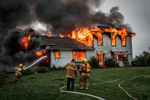 Firefighters putting out a house fire.| Photo: Shutterstock.