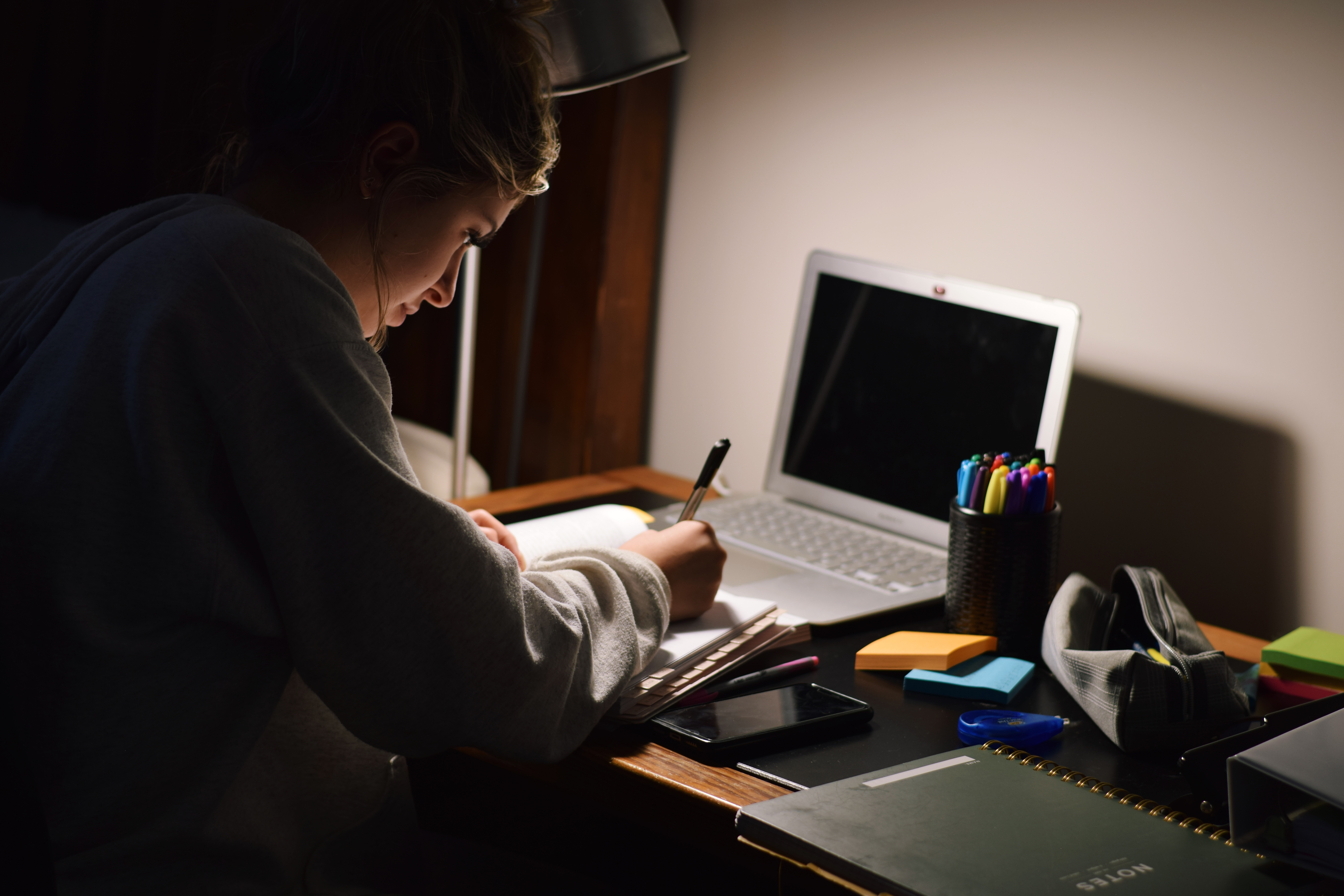 Young teenage girl student studying late at night in her room. | Source: Shutterstock