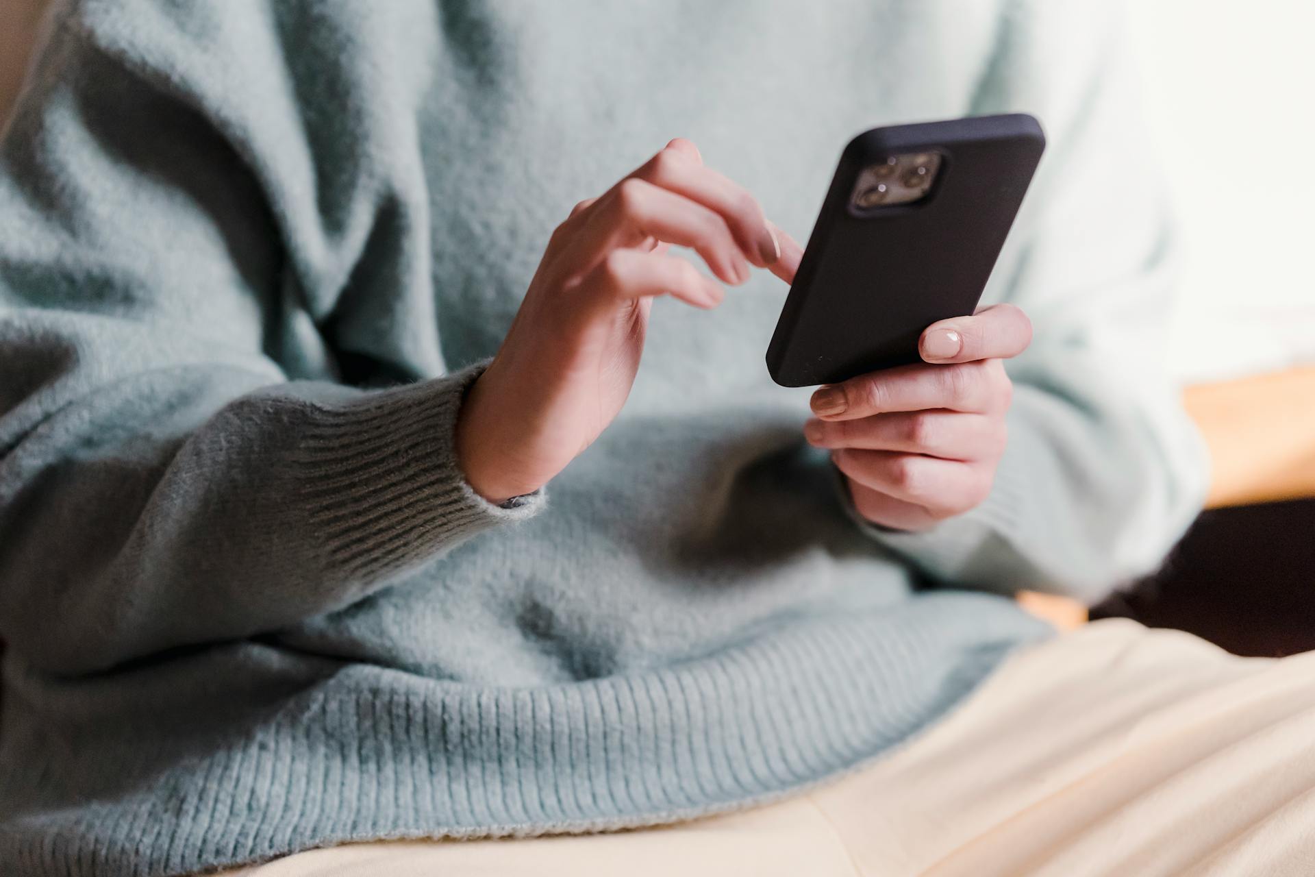 A woman scrolling on a phone | Source: Midjourney